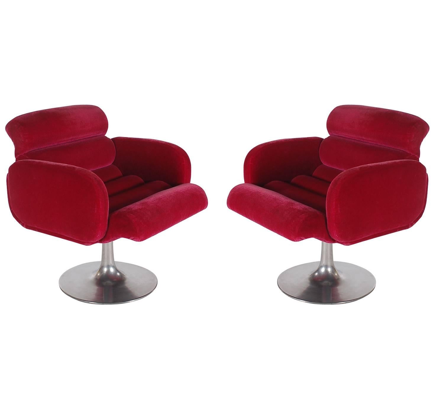 An interesting matching pair of swivel armchairs designed by Stendig and produced in the 1960s. They feature red velvet upholstered seats with aluminum tulip bases. 

In the style of: Milo Baughman or Pierre Paulin.