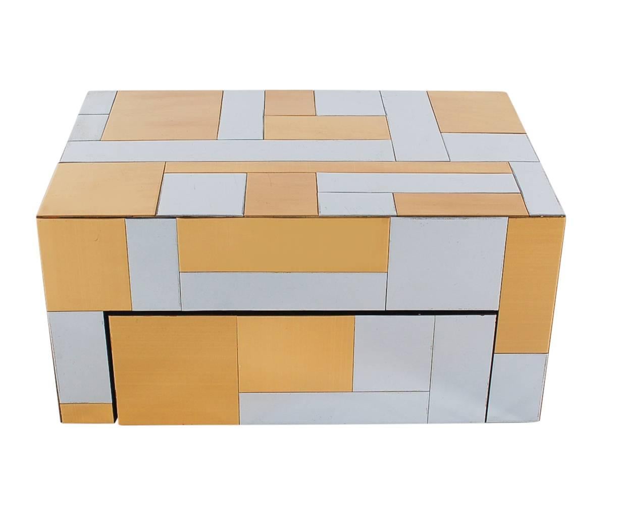 A Classic two-tone cityscape design by Paul Evans for Directional. This wall-mounted cabinet features brass and chrome design panels, with a pull-out drawer with black satin interior. Perfect for a nightstand or console table.