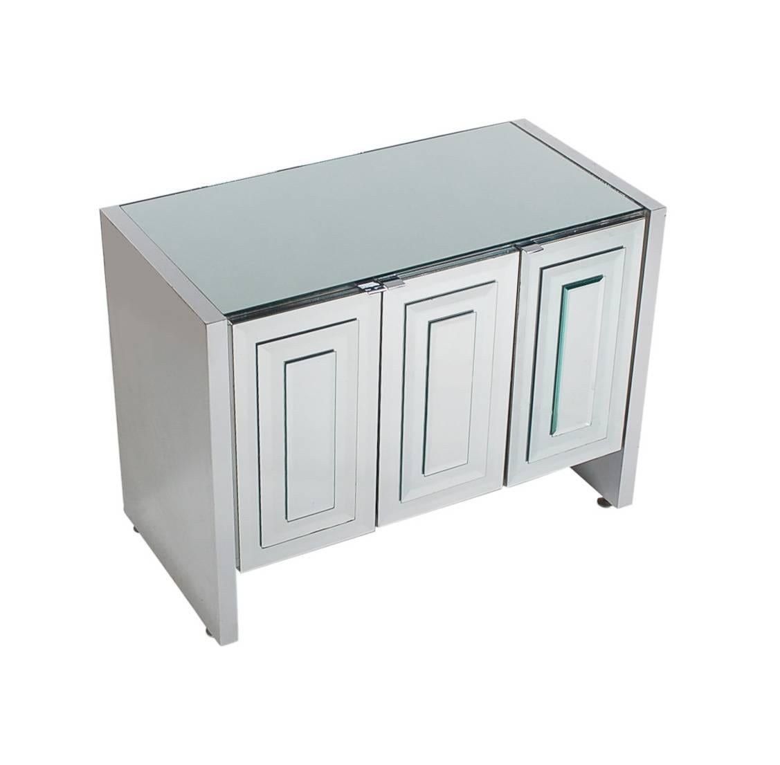 A chic and glamorous mirrored three-door cabinet made by Ello. It features Art Deco Mirror stacked doors with chrome trim. Interior is off-white laminate. 

In the style of: Pierre Cardin, Mastercraft, Paul Evans, Hollywood Regency.