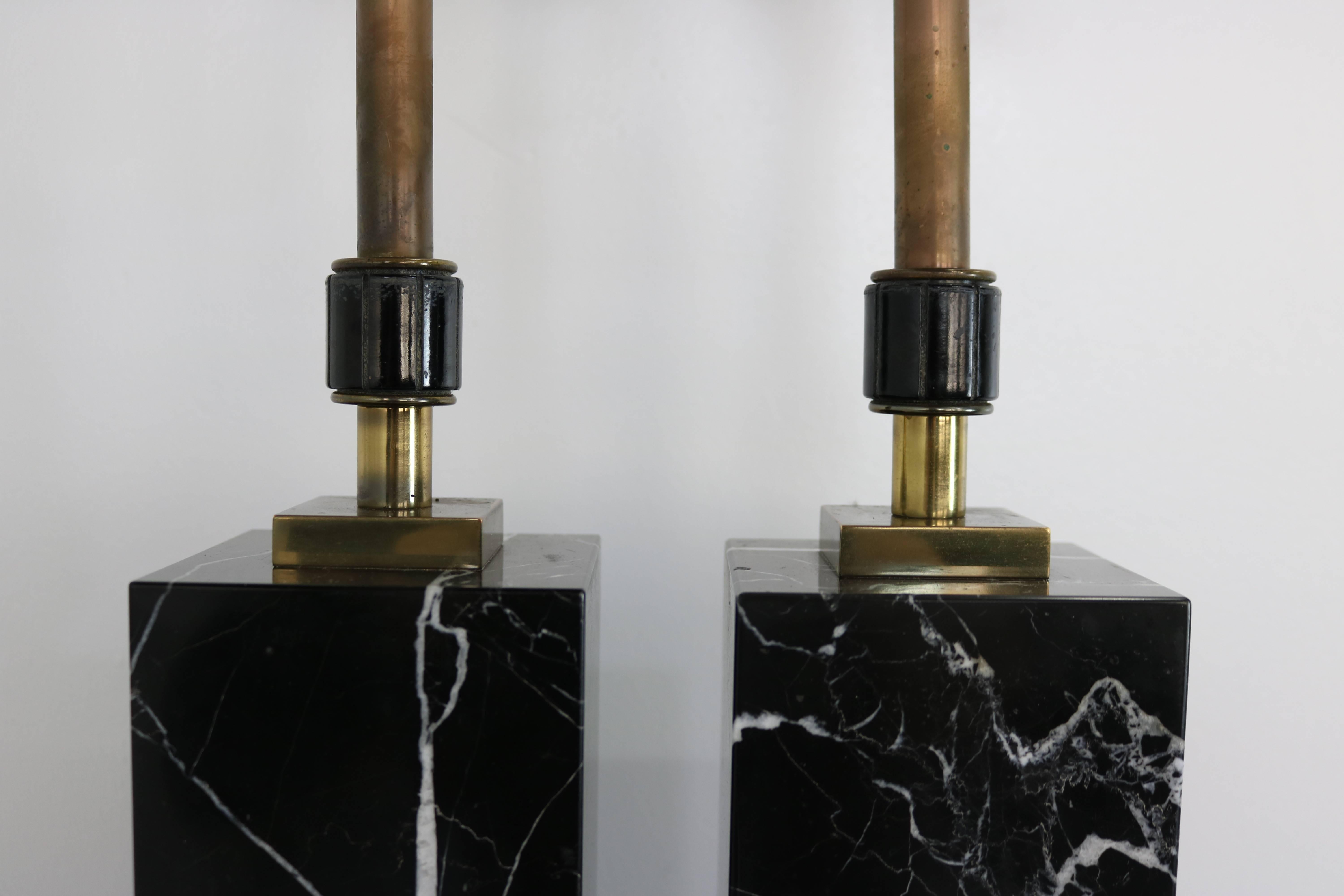 Gorgeous black marble column lamps with prominent white veining. Original brass and porcelain hardware and distinctive turn switches.

30 inches to top of socket. 15 inch marble base.