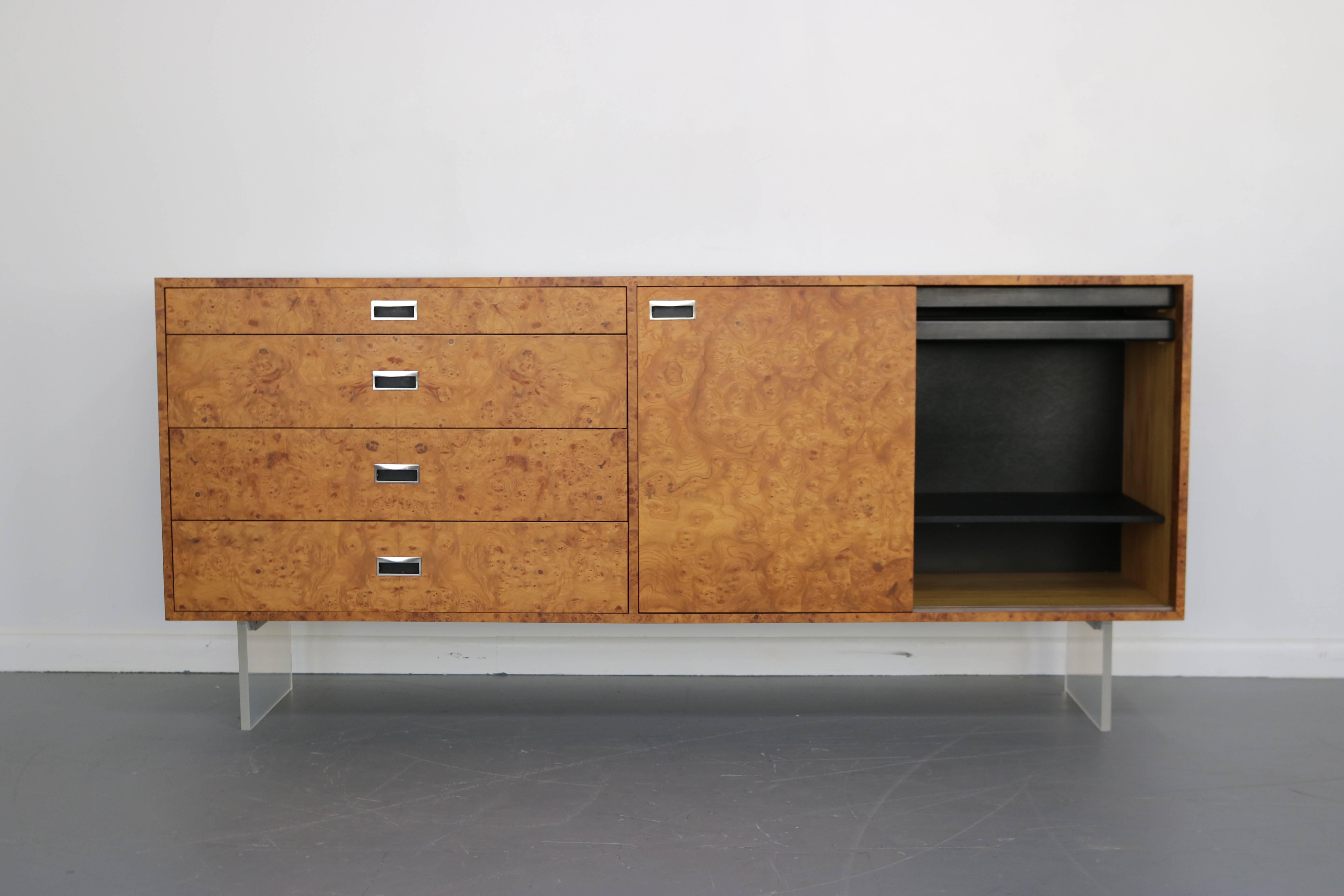 Sleek and elegant, this credenza was custom ordered in 1972 and is as lovely as ever! Left side contains four drawers, centre has two small hidden drawers and one adjustable shelf and right side has two hidden drawers and two adjustable shelves.