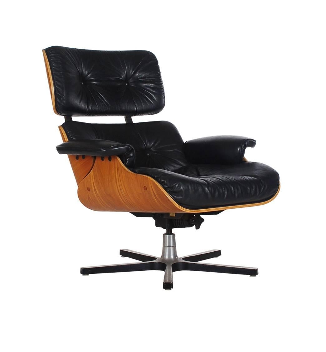 An iconic looking black leather lounge chair made by Plycraft in the early 1970s. It features a walnut plywood back, black leather cushions, swivel aluminium base, and tilt mechanism. Very well cared for and ready for immediate use. 

In the style