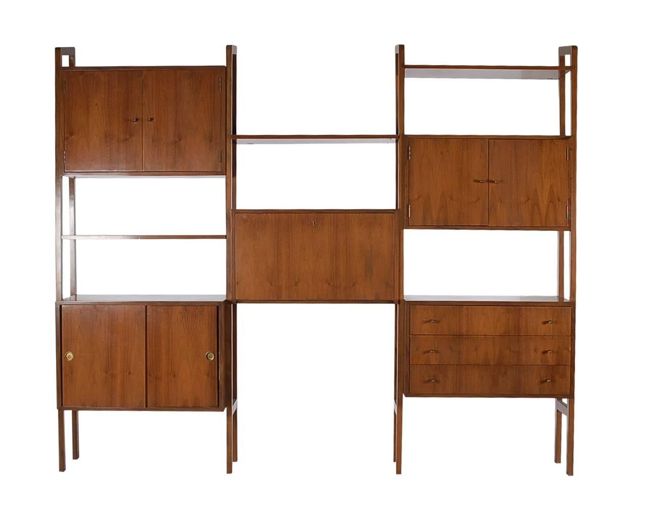 A large freestanding wall unit with tons of functionality it features solid walnut construction, several cabinets, shelves, and pull down secretary desk.

In the style of Poul Cadovius.