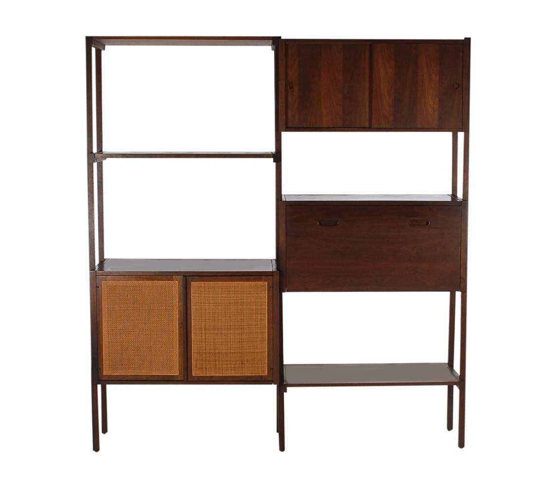 A beautiful freestanding storage piece that can be utilized in any room of your home. It is fully modular and adjustable to suit your needs. It features solid walnut construction with cane details.