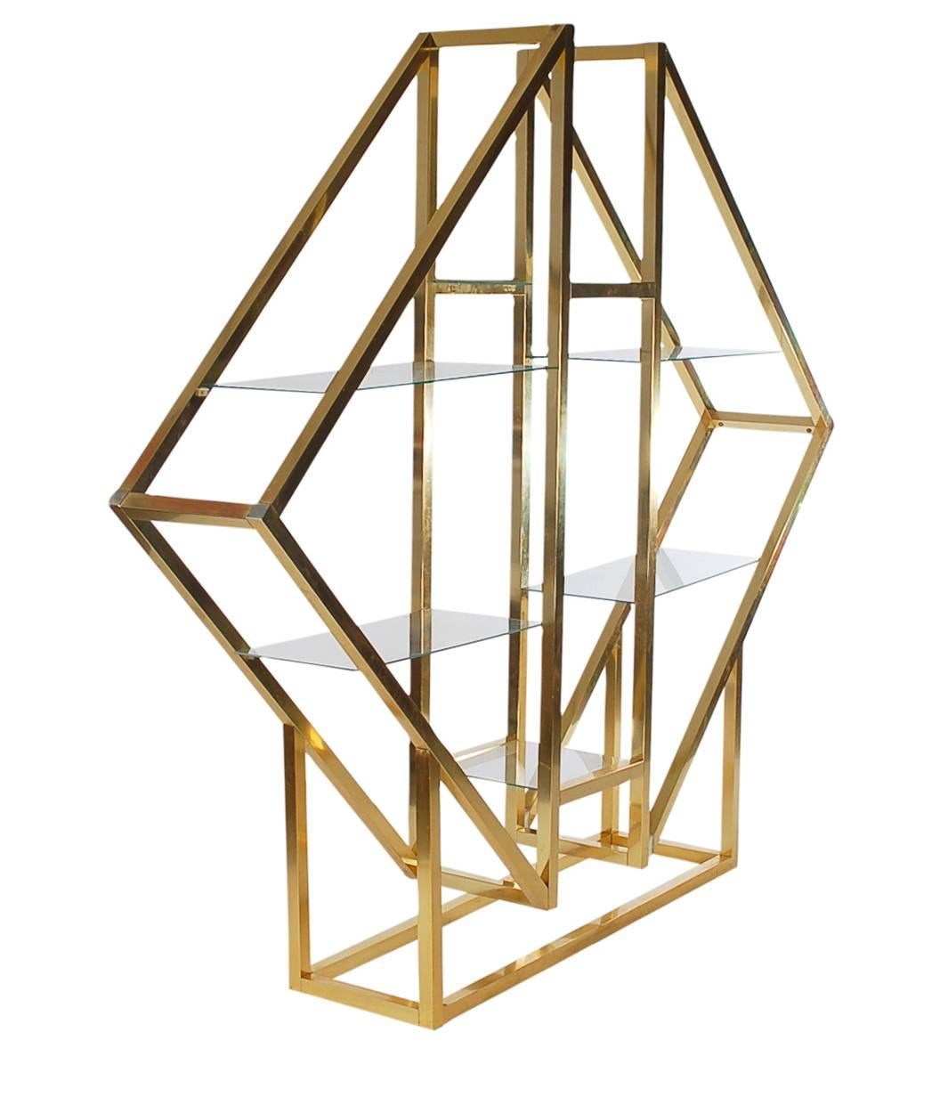 A large diamond form étagère in the manner of Romeo Rega. It features brass plated aluminium framing with six floating glass shelves.