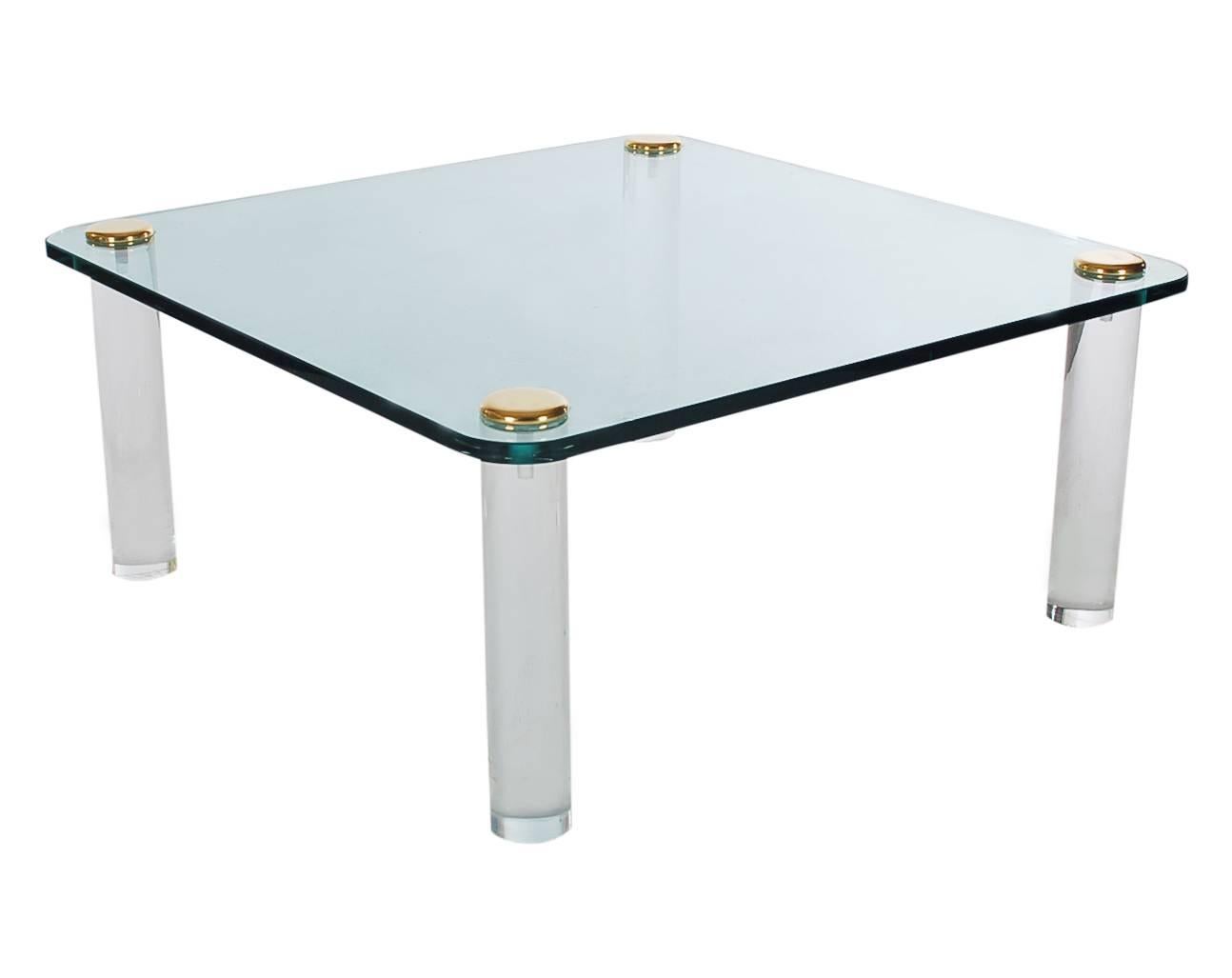 A smaller scale coffee table designed by Leon Rosen for the Pace Collection. It features extra thick acrylic legs with a floating glass top. 

In the style of: Karl Springer.