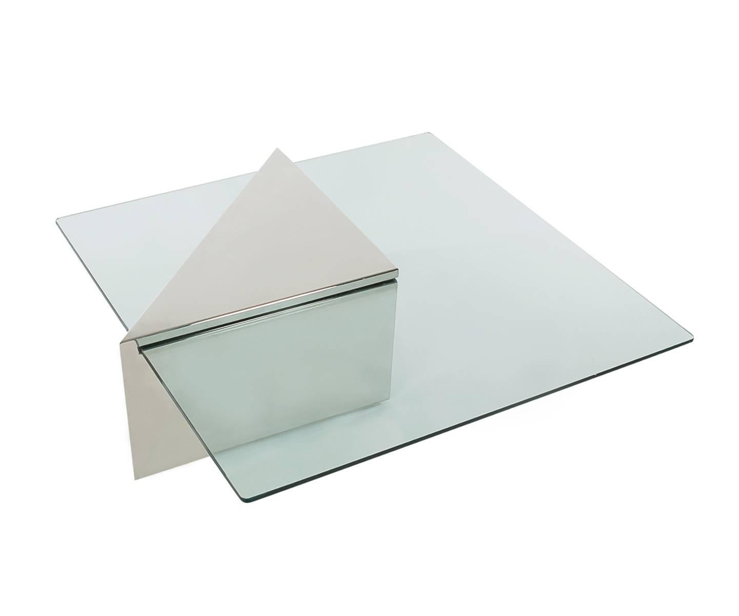 A super classy looking coffee table designed by J. Wade Beam for Brueton furniture company. It consists of an extremely polished stainless steel triangular base that holds a thick piece of floating glass. Two available and priced each.