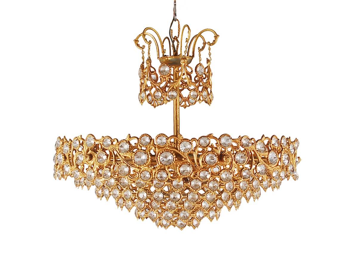 A gorgeous vintage crystal chandelier, probably Italian or French dating back to the 1960s. It features a gold gilt bronze frame with 100s of beautiful crystals. Tested and working.