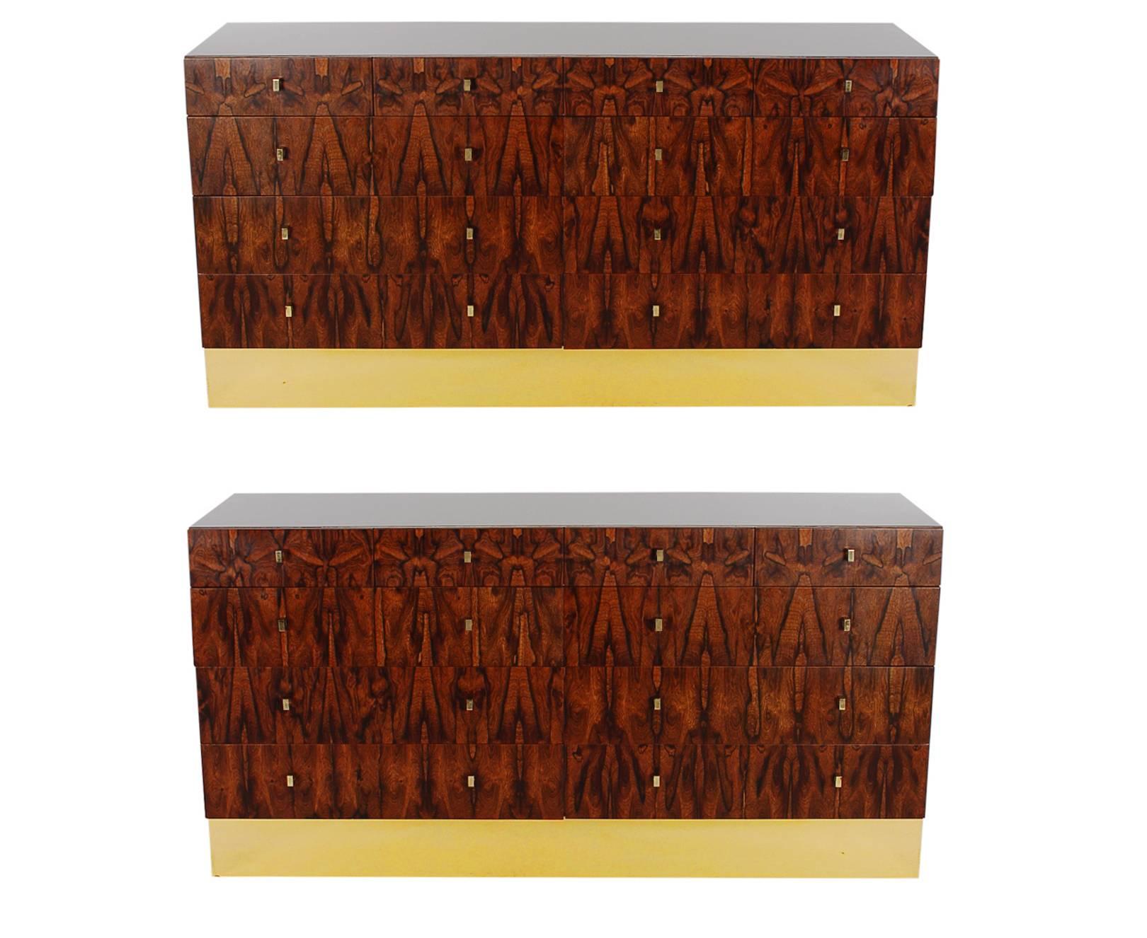 A super handsome and sophisticated pair of ten-drawer dressers or credenzas made by Rougier. They feature well-made laminate cases, with beautiful rosewood drawers, and brass plinth bases. Very much in the style of Milo Baughman. Pair available and