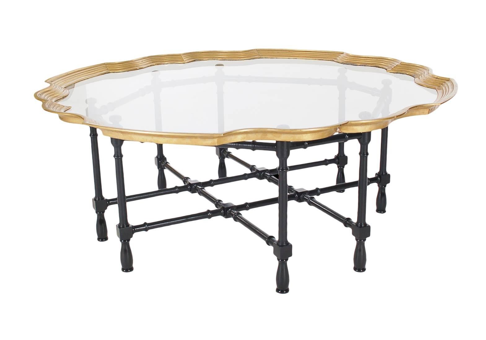 A chic and beautiful tray table with a faux bamboo base. It features a solid wood ebony bass with brass and glass top surface.