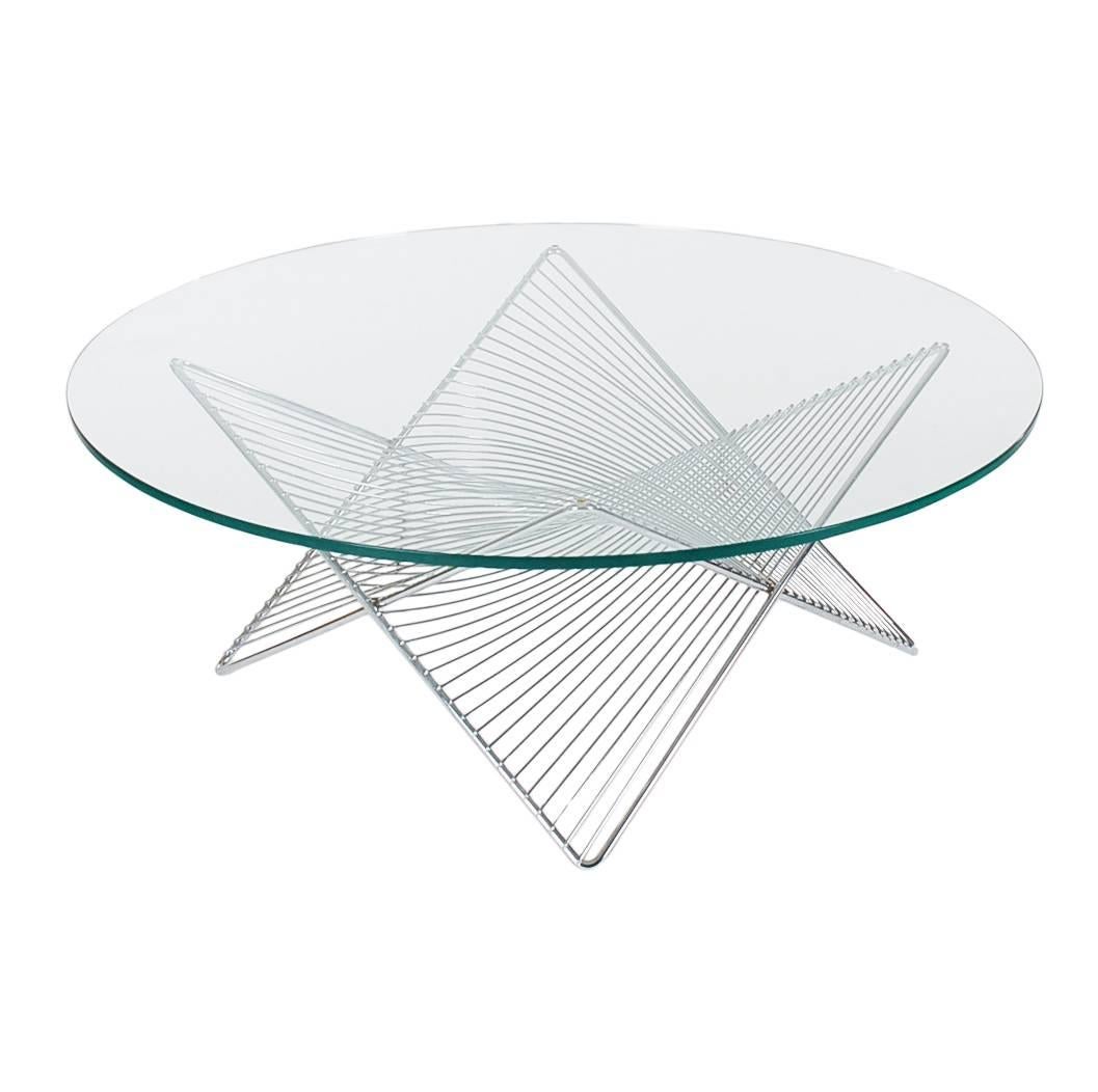 An incredible form cocktail table, circa 1970s. It features a chrome plated wire base with round glass top. Very much in the style of Harry Bertoia or Warren Platner for Knoll.