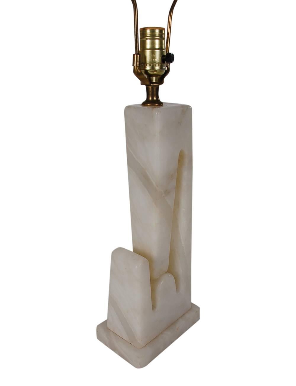A sculptural marble table lamp produced in Italy in the 1960s. It features a heavy solid alabaster base in an art deco form. Tested and fully working.