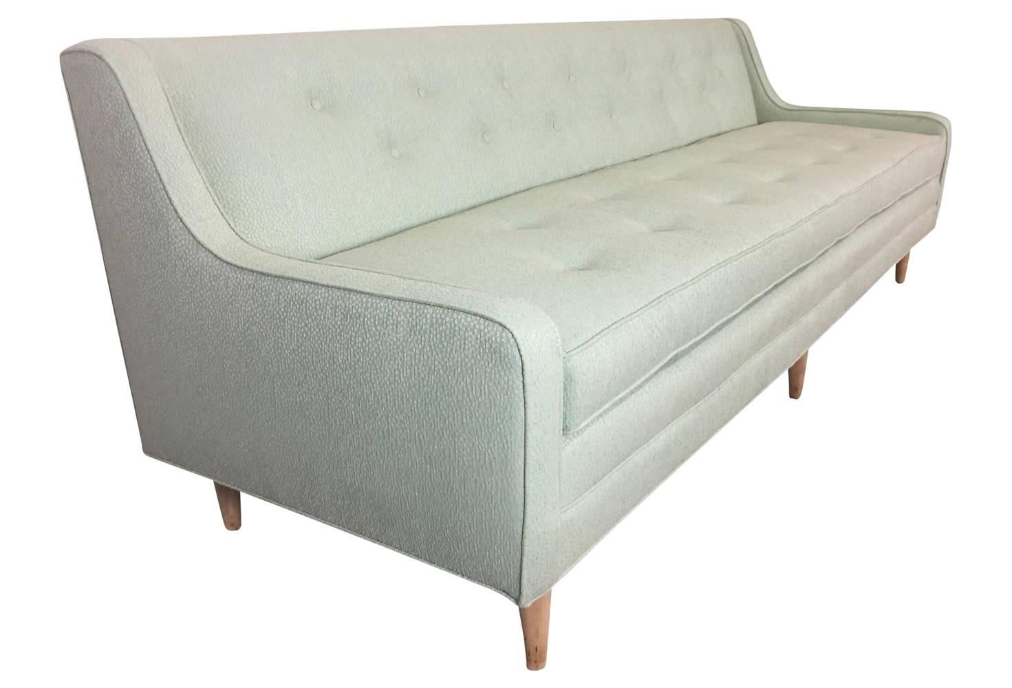 This gorgeous vintage Mid-Century Modern sofa has been lovingly restored. The upholstery is a lovely light green with cream 