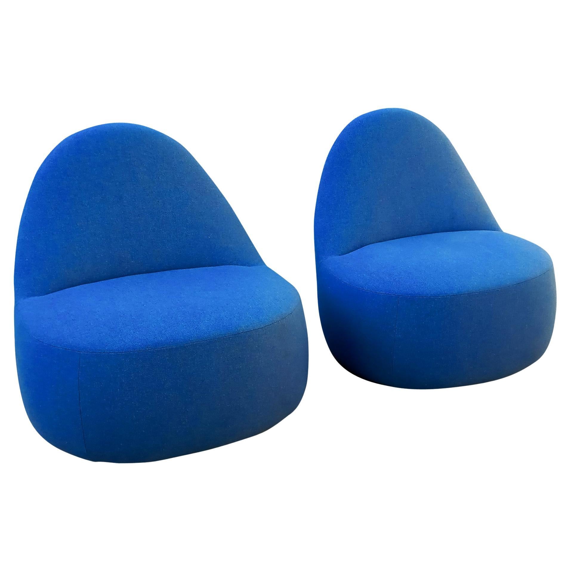 This pair of elegant and space-age chairs was designed by Claudia and Harry Washington for production by Bernhardt Design. They are dressed in a rich blue color, and feature a strap on the back for increased handleability. The strap runs down the