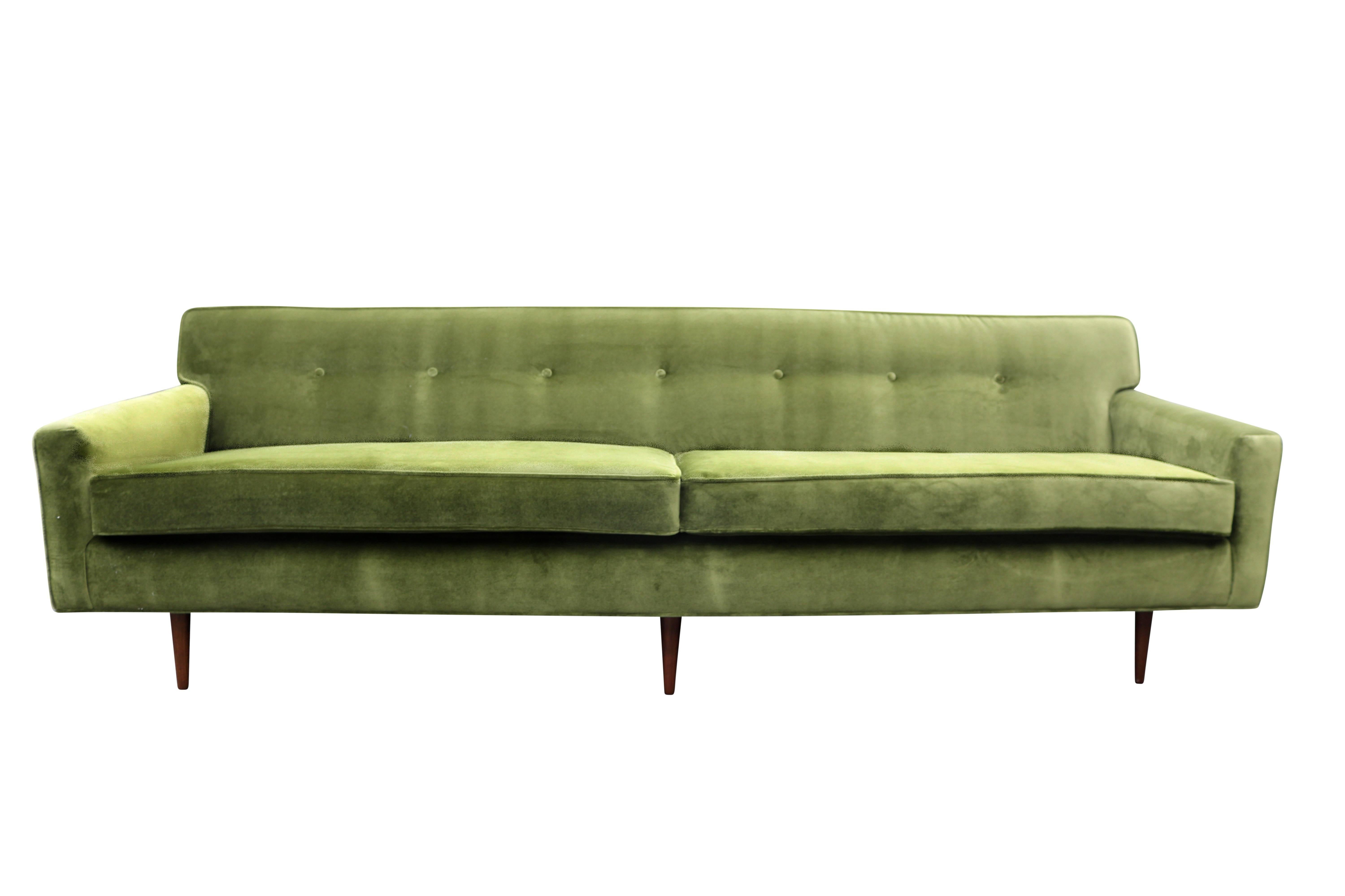 This long and low vintage Mid-Century Modern sofa has been completely restored and covered in a luscious green velvet. Seven button detail and walnut legs give it a distinctive look.