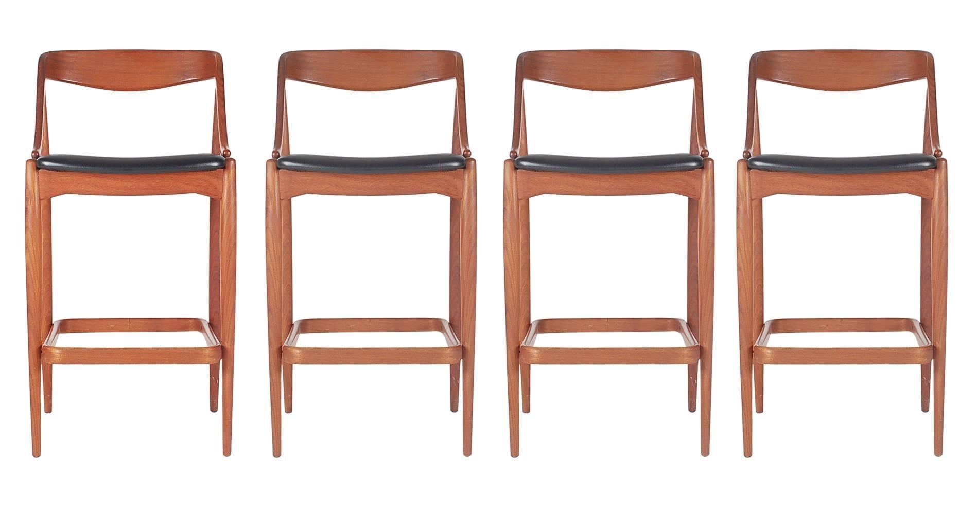 A complete set of four teak barstools designed by Johannes Andersen for Morredi. The stools feature sculptural teak frames with the original black naugahyde cushions. 

In the style of: Eric Buch, Erik Buck barstools, Hans Wegner