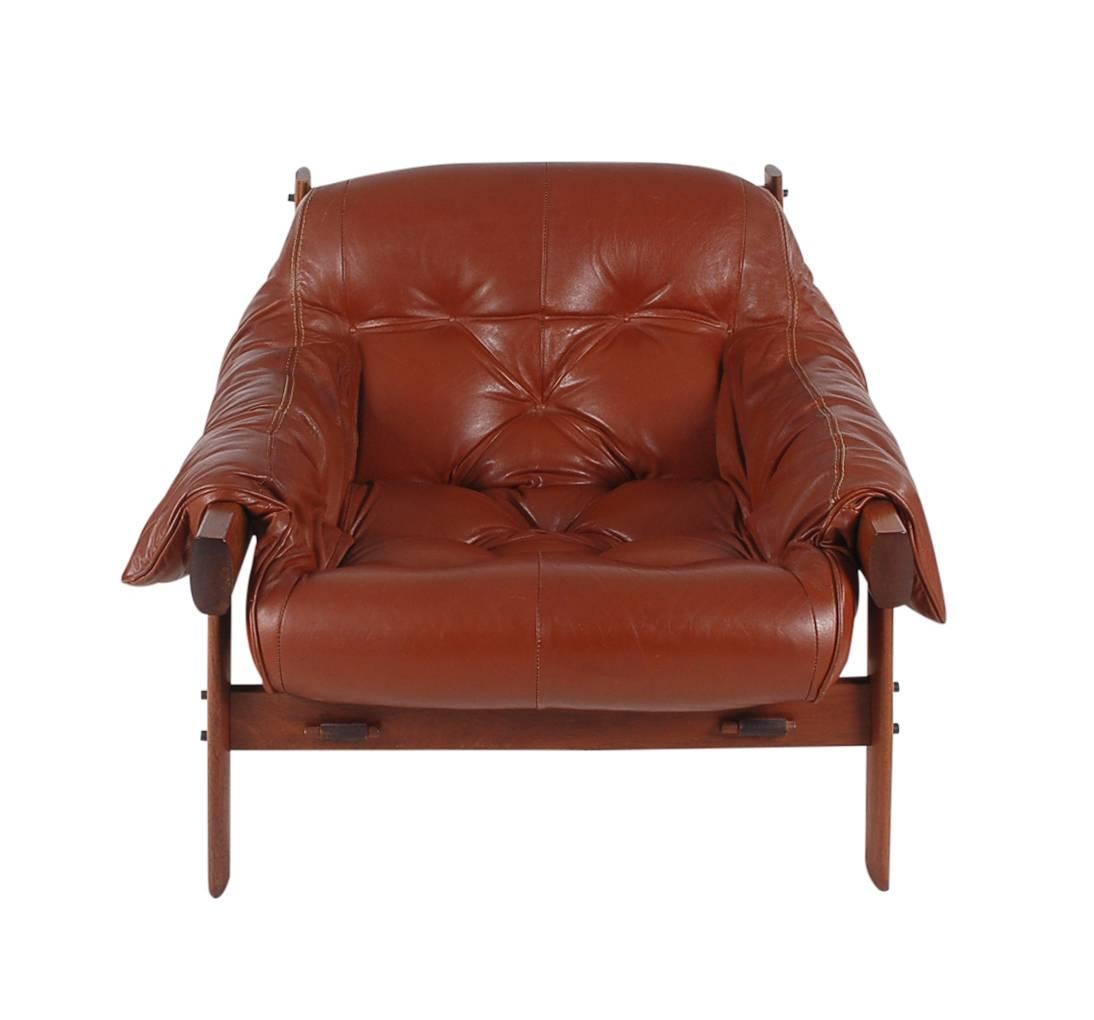 An extremely comfortable rosewood and leather lounge chair designed by Percival Lafer in Brazil. It features a solid rosewood frame with a soft leather sling upholstery. 