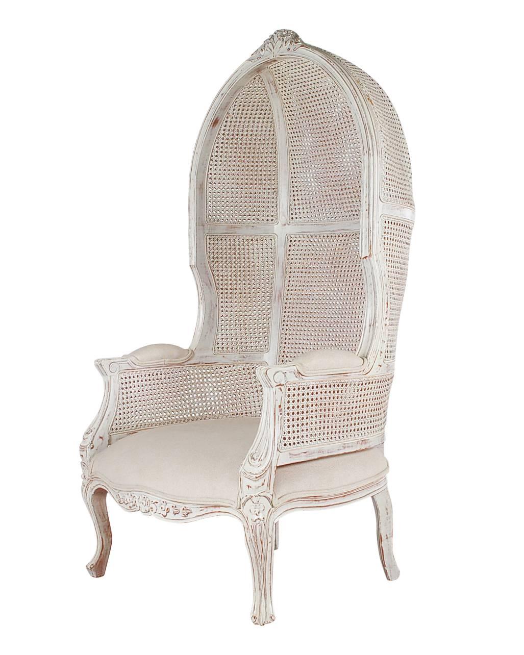 A very well made hood chair in solid mahogany. It features a distressed finish, two layers of caning, and upholstered seat and arms. 