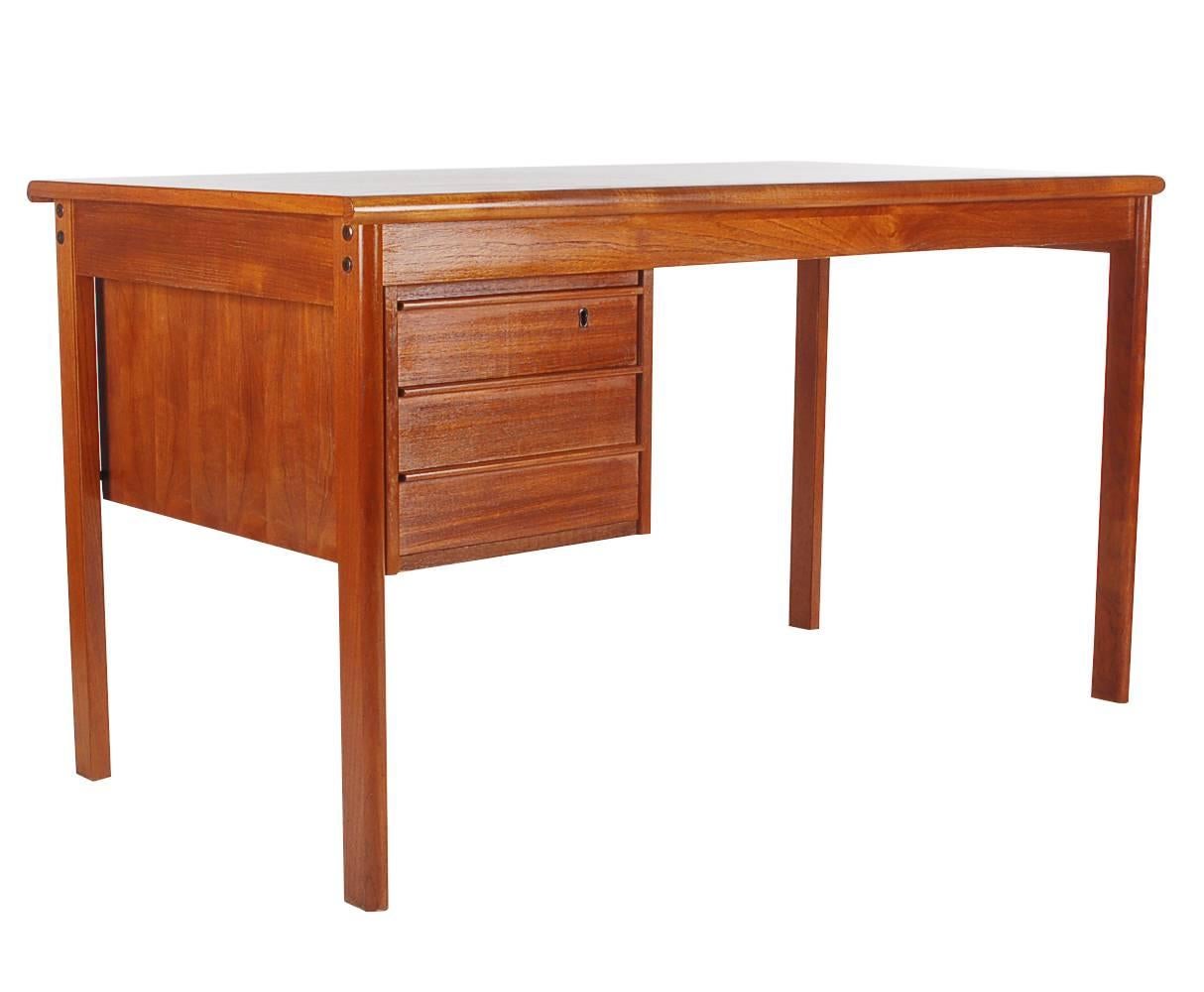 A wonderful and simply designed teak desk by Peter Lovig Nielsen for Dansk. It features teak construction, with a sliding top and hidden compartment. Manufactures makings. We currently have five matching desks available. Priced each.
