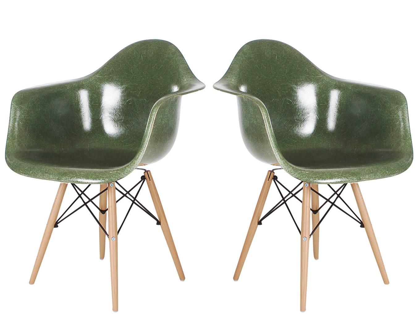 A beautiful matching pair of hunter green armchairs designed by Charles Eames for Herman Miller. Chairs are vintage circa 1960s, bases are newer reproductions.
