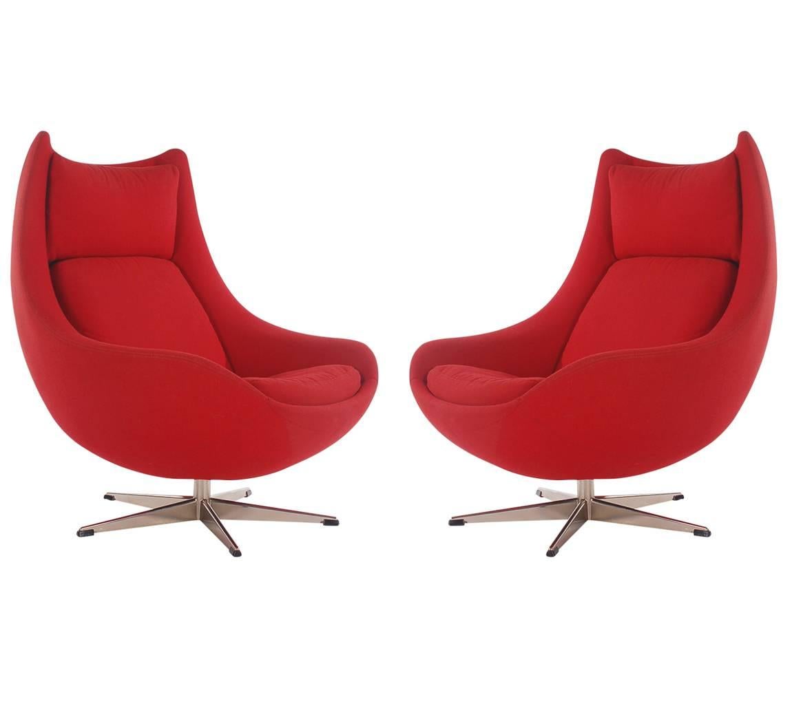 A sculptural pair of egg lounge chairs designed by H. W. Klein for Bramin furniture in Denmark. They feature 360 degree swivel bases with the original red tweed upholstery. 

In the style of: Arne Jacobsen, Fritz Hansen.