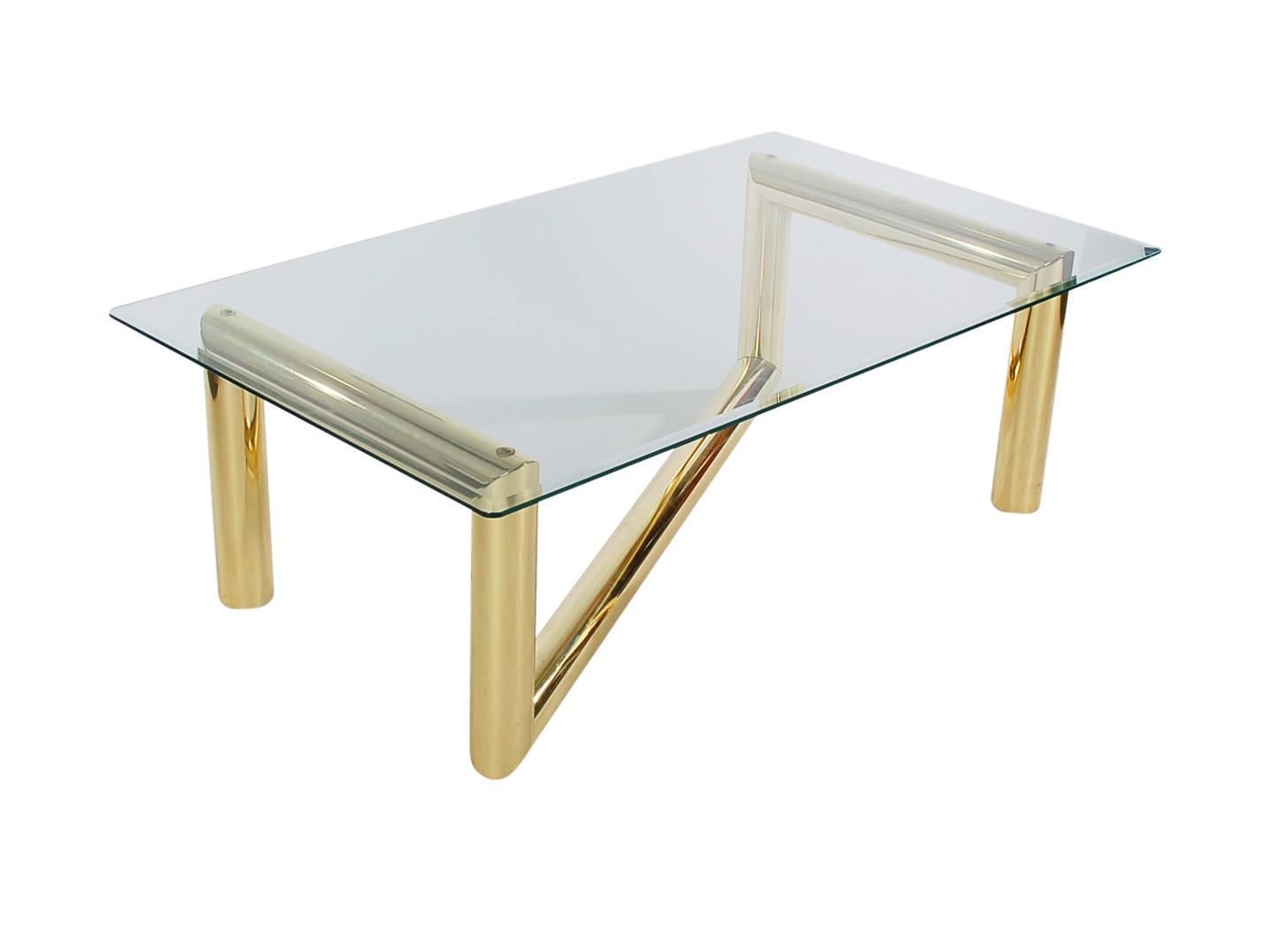 A funky and fun cocktail table. It features a thick chunky brass tubular base with clear glass top.