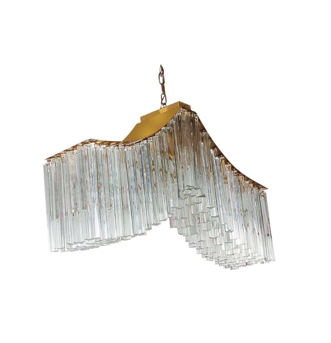 An incredibly stunning Italian chandelier in the shape of a whale tail. It features brass framing and nearly 200 glass prisms. Tested and fully working.