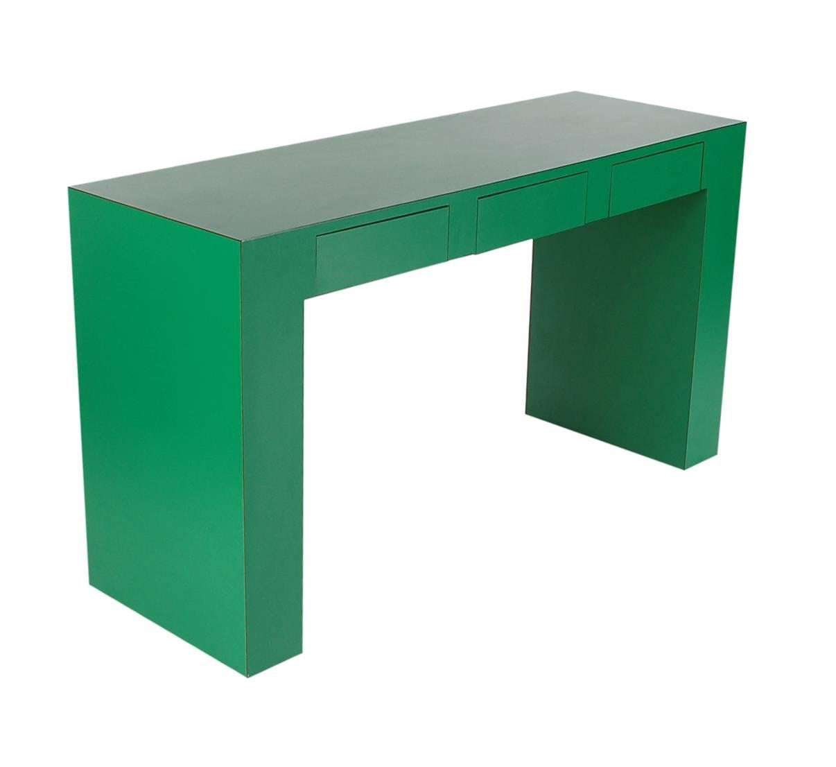 A uniquely thick proportioned console table or desk. It is very well made and features an emerald green laminate finish with three drawers.

In the style of Milo Baughman or Karl Springer.
