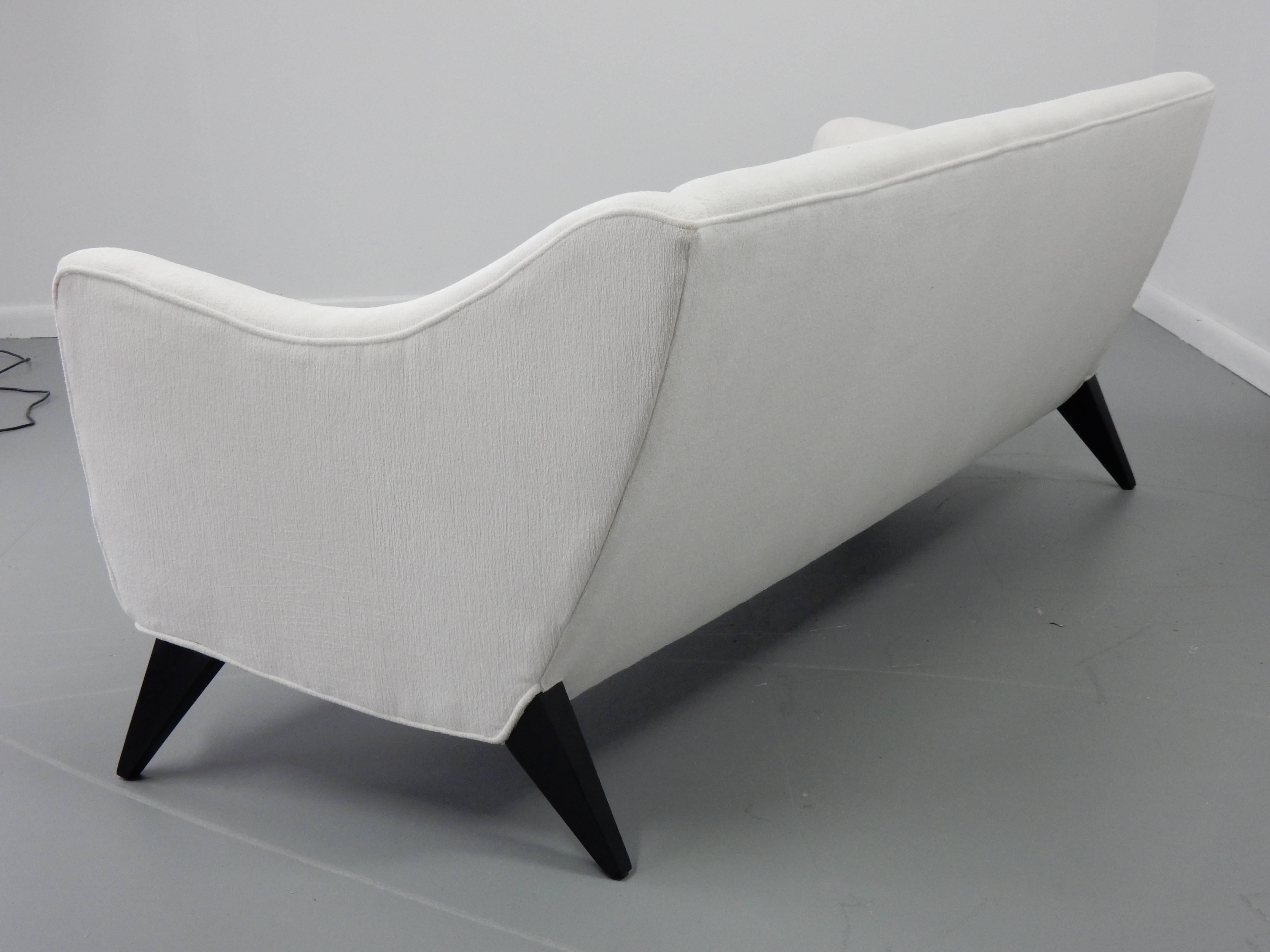 This 1950s Italian sofa has been through a ground up restoration; we've ebonized the legs and upholstered this voluptuous shaped piece in a lovely white textured velvet.