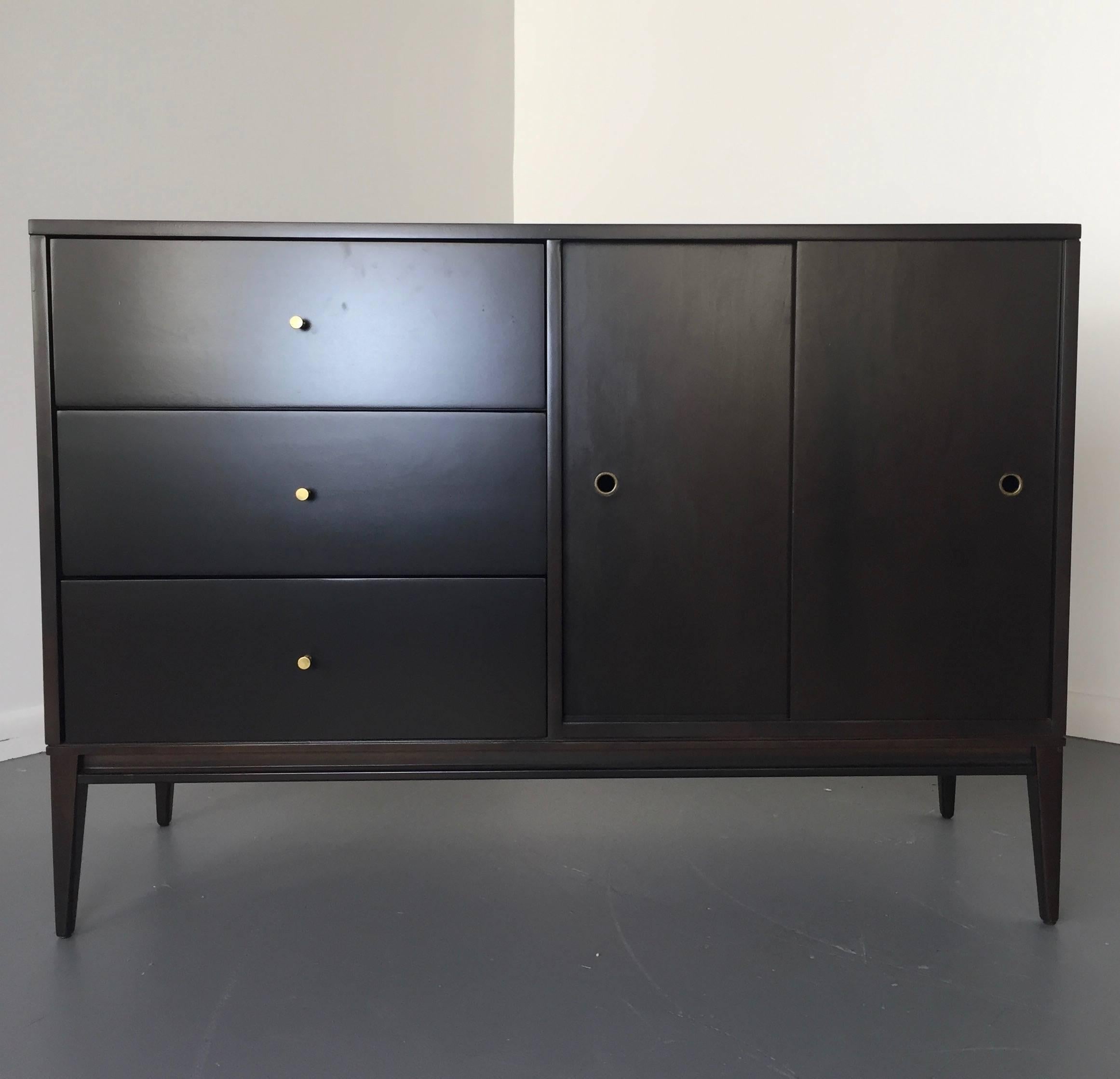 This small sideboard was designed by Paul McCobb for Winchendon Furniture Co. It has had a ground up restoration refinished with a beautiful dark stain.