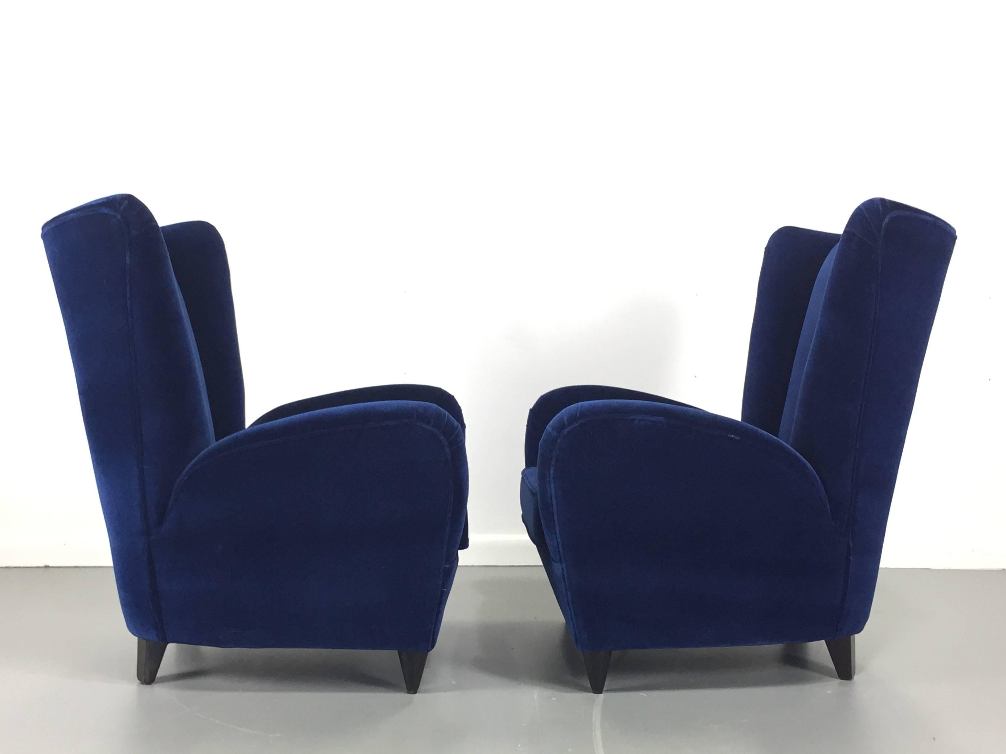 These petite lounge chairs designed by the famed Italian designer Paolo Buffa have been professionally restored in a sumptuous navy velvet. Manufactured in Italy in the 1950s these chairs give you that wonderful club chair feeling of being hugged.