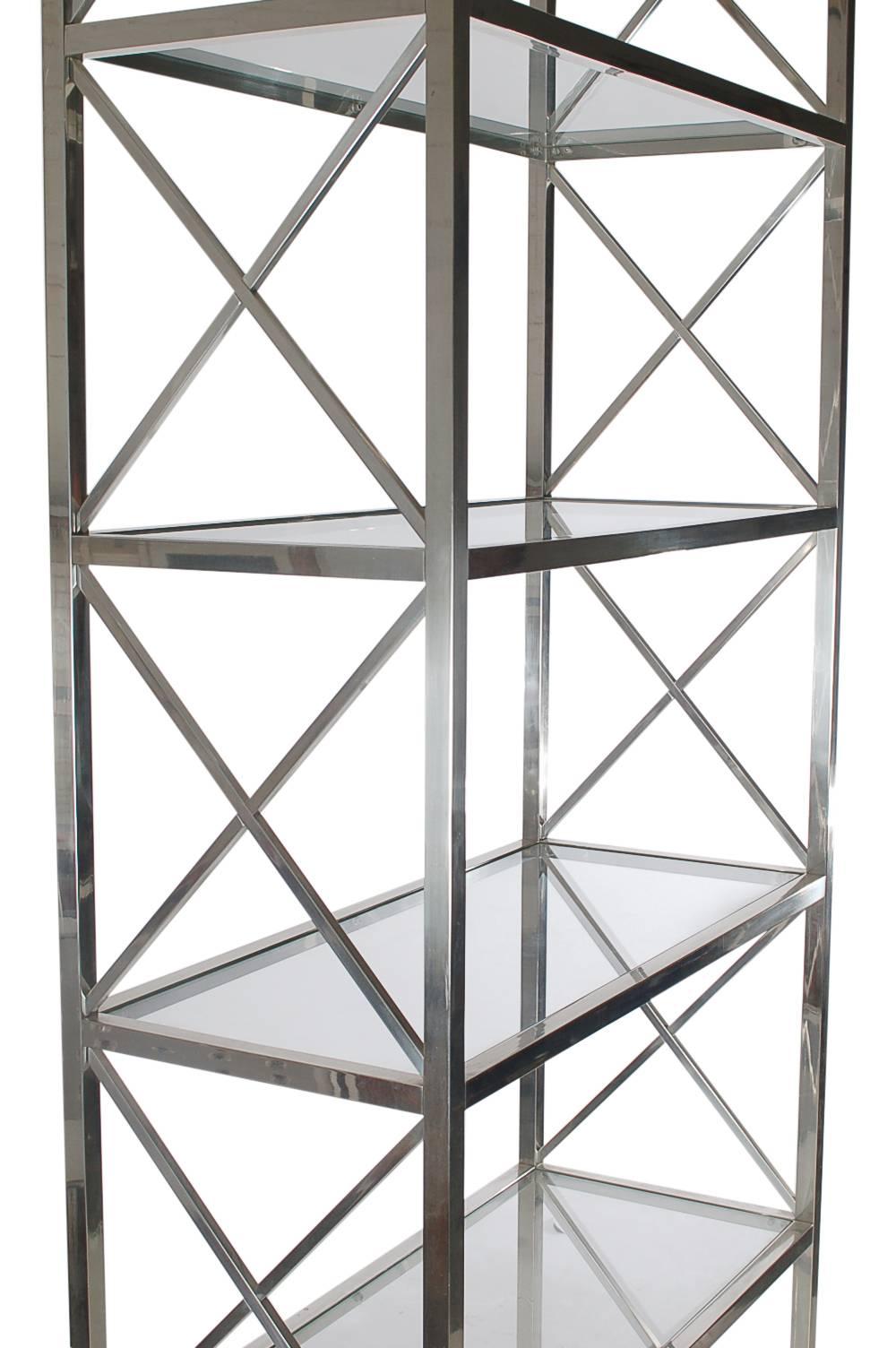An extra tall and extra handsome etagere in the style of Maison Jansen or Milo Baughman. It features a polished aluminium frame with several heavy clear glass shelves.