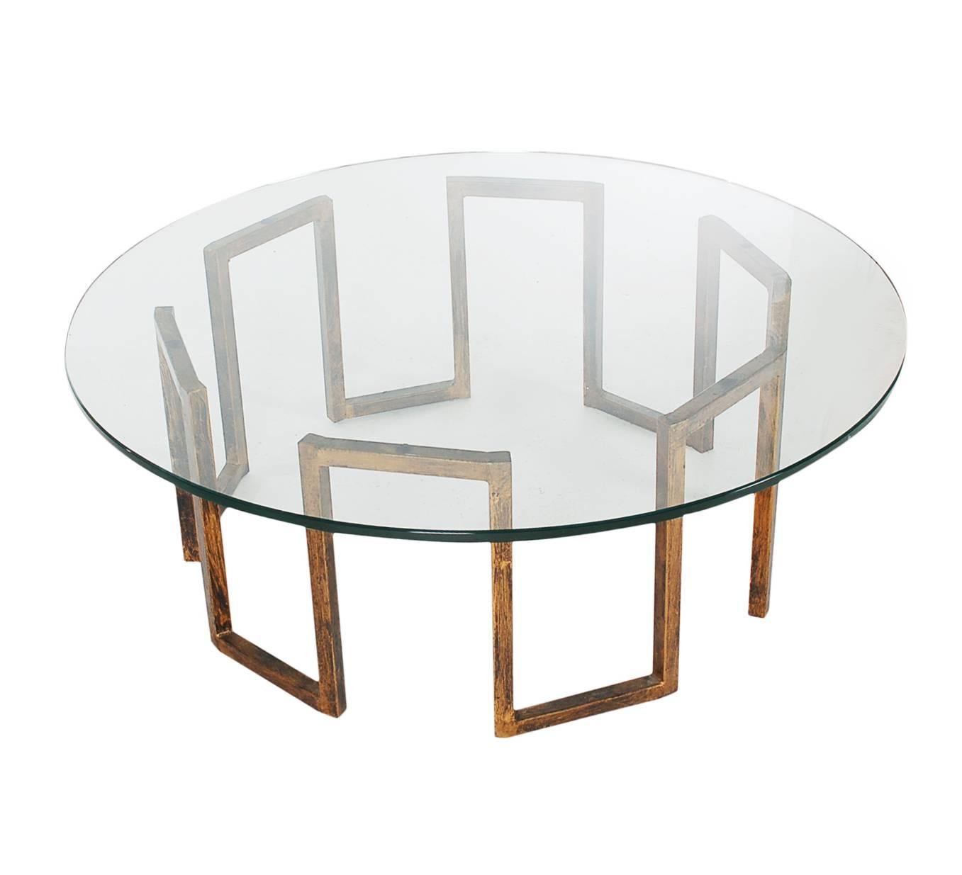 A chic and stately coffee table, circa early 1970s. The table features a faux distressed brass base with heavy 3/4 inch glass top.

In the style of Mastercraft.