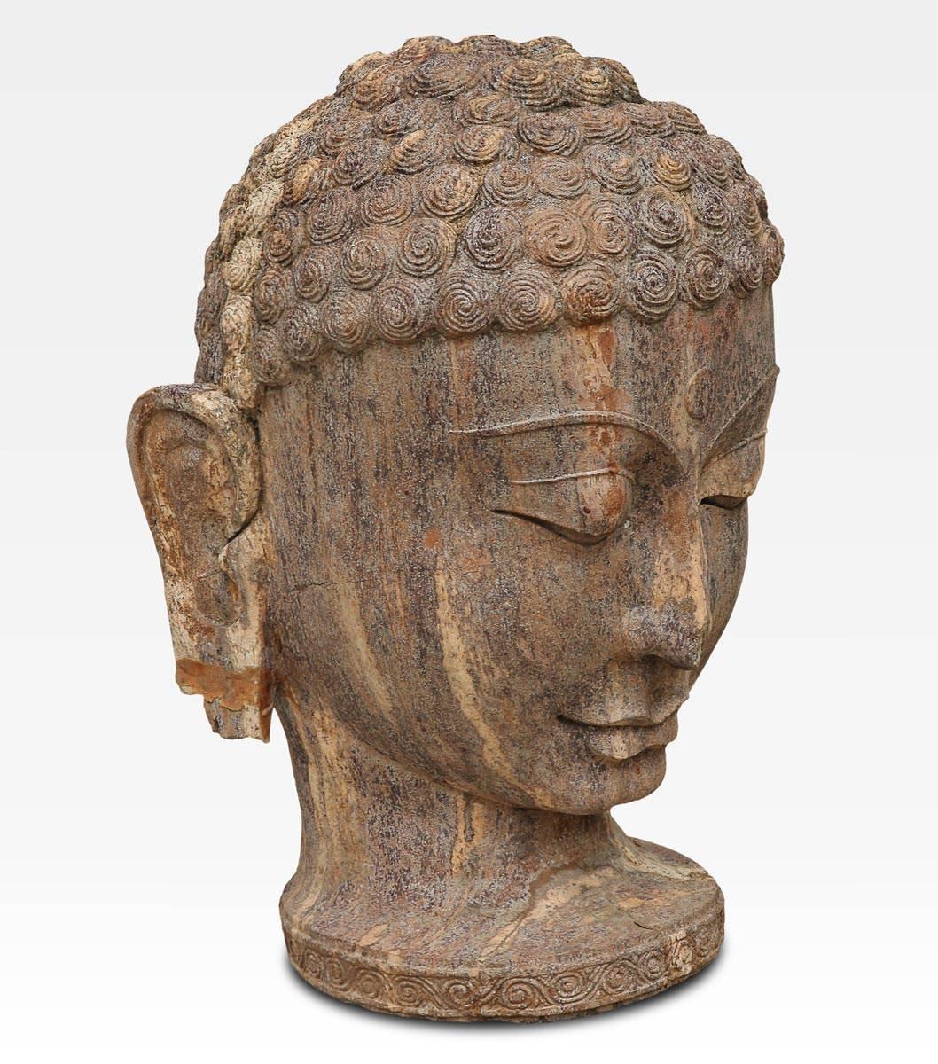 This sculpture of the Buddha follows the traditional Buddhist iconography: The long ears are symbol of knowledge, the third eye, carving in the middle of forehead, is symbol of the inner life. The strong effect of the expression conveys peace and