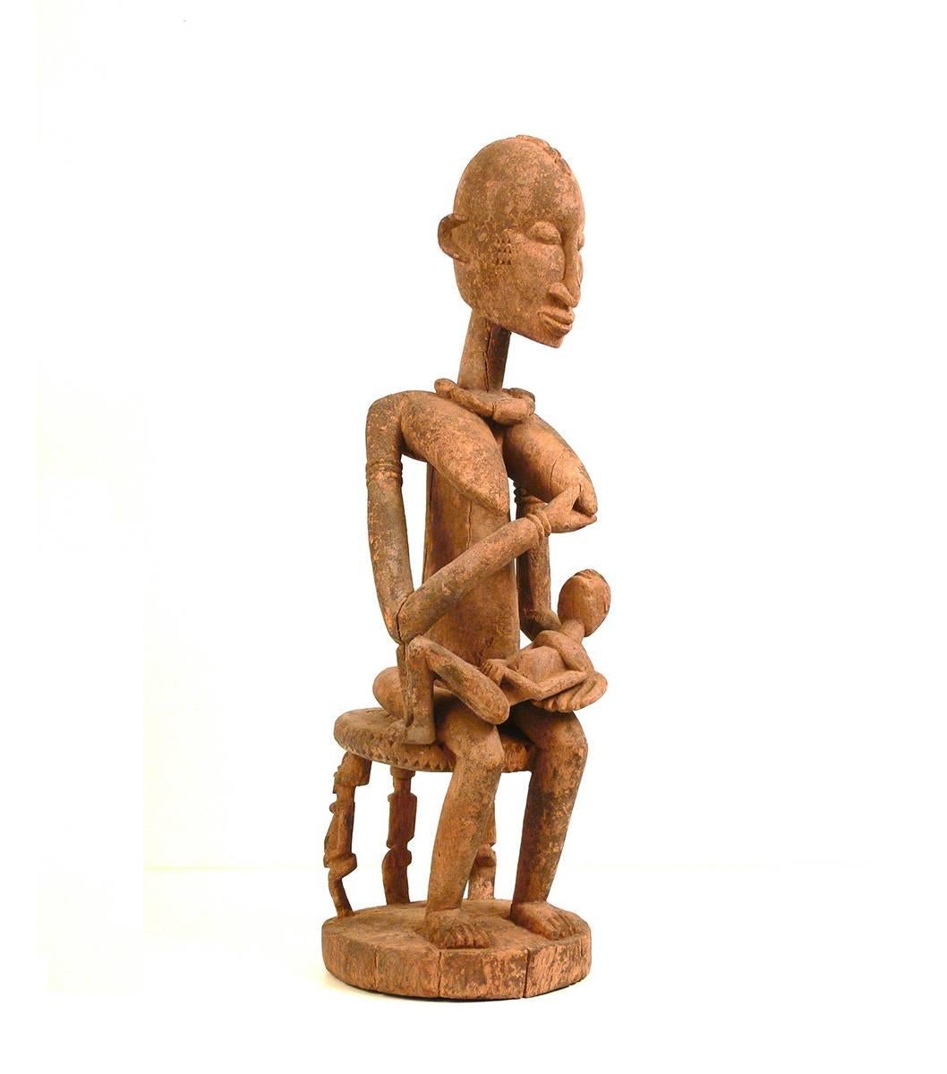 This old maternity figure represents in a fine work of art the mythical ancestor and symbolically the feminine ideals of beauty and fertility. This kind of wooden statues were commonly used as shrine figures, in order to ensure births and prosperity