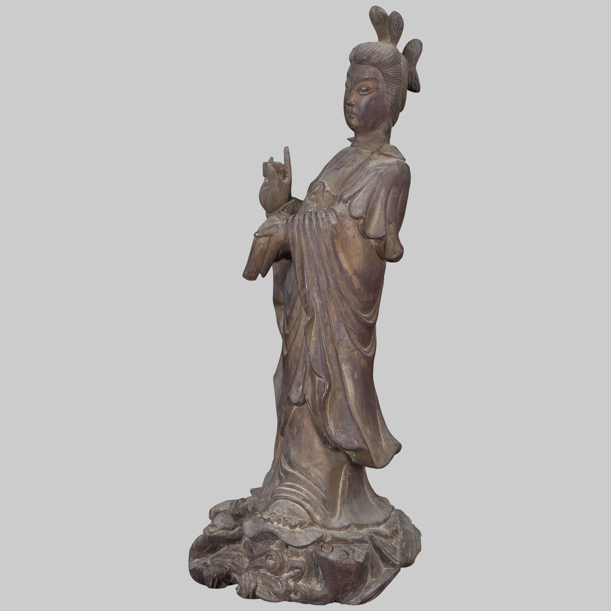 Beautiful Guanyin. Goddess is depicted standing, always looking down, towards those who suffer.

The right hand is raised in Karana mudra, which expels demons and removes obstacles such as sickness or negative thoughts. It is made by raising the