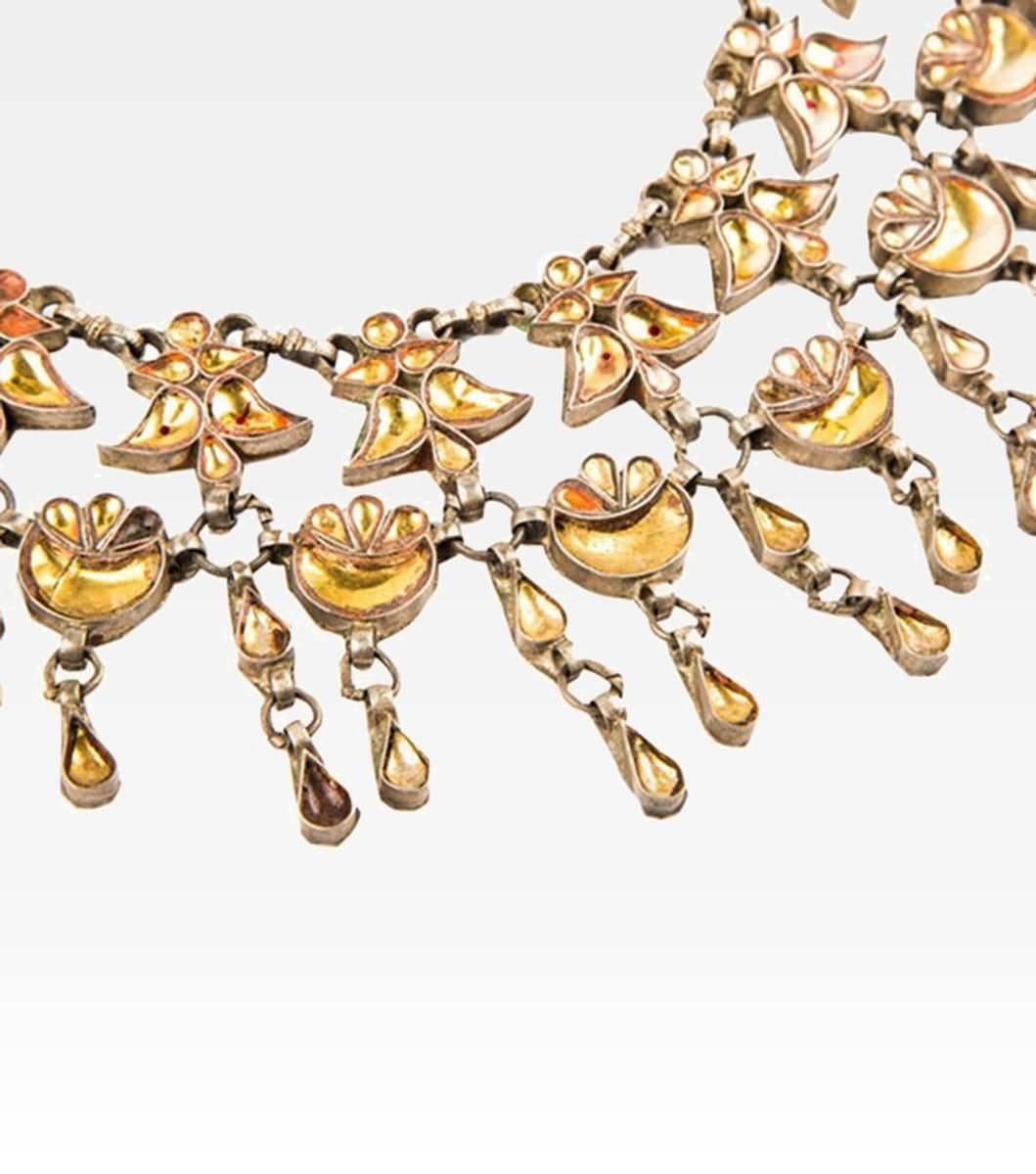 This beautiful Indian necklace recalls the splendor of the imperial courts and the beauty of oriental princesses. An old piece of timeless beauty but made up of many little silver drops with embedded yellow enameled glass. A very elegant jewel and