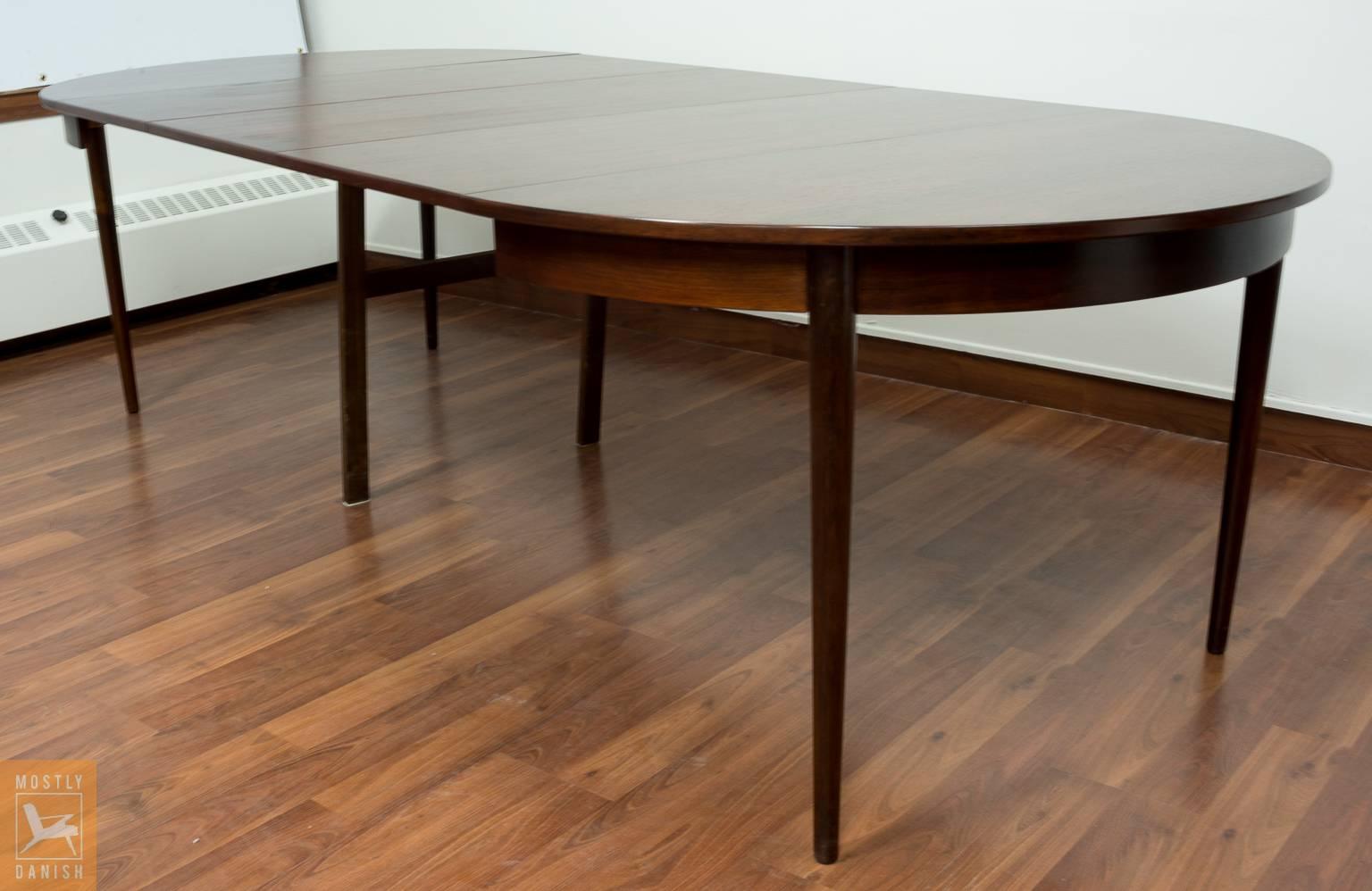Round dining table veneered rosewood 73 cm x 118 cm, with five additional extension at 48 cm/ each, with a center leg support. Very rare rosewood table at this size.