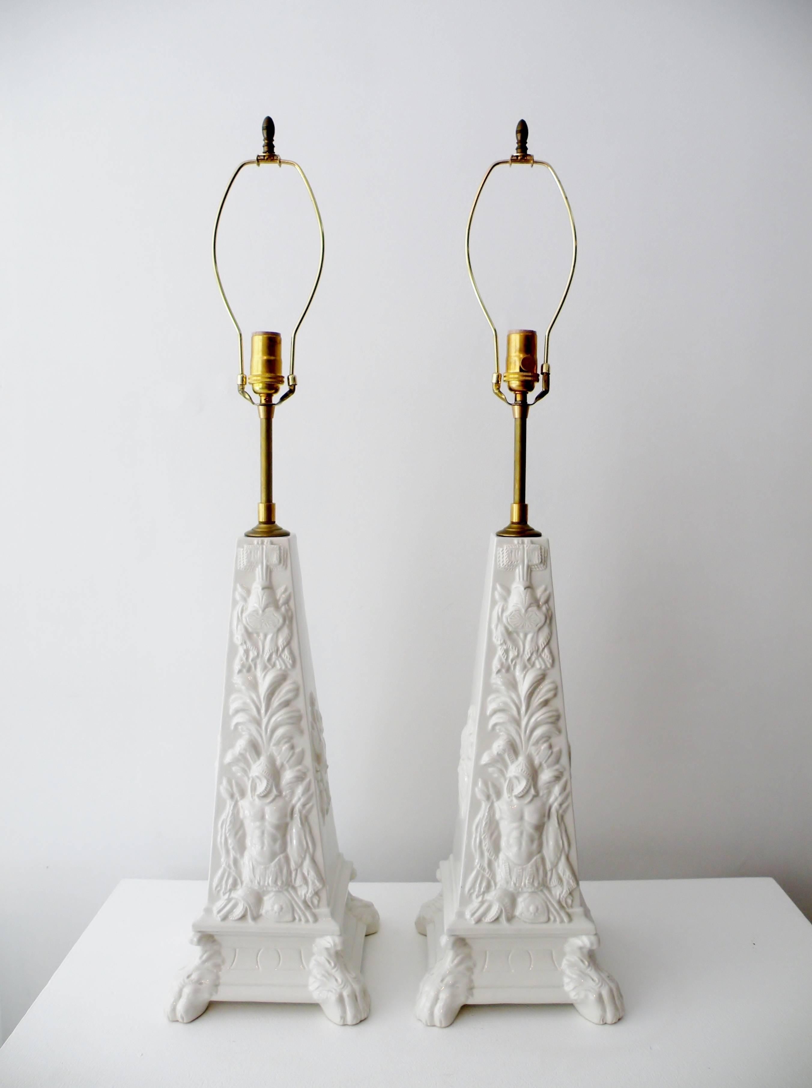 1970s era Italian pottery Blanc de Chine obelisk form table lamps from the renowned studios of Mottahedeh. Each with high relief classically decorated side panels, unique front and back and two side reliefs with lion feet. Body of each measures