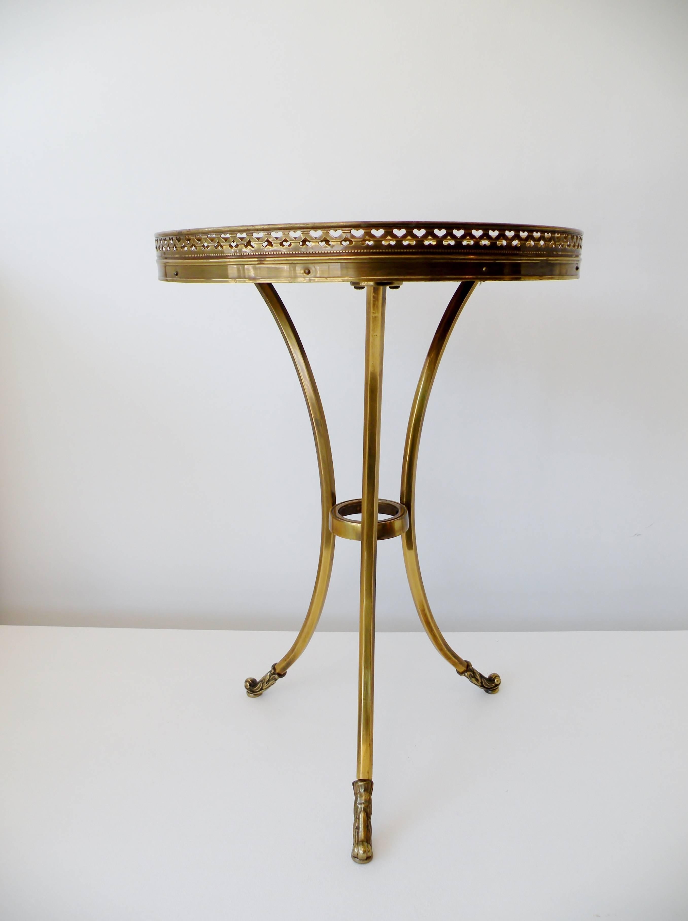Rarely seen Mastercraft for Baker petite brass tripod cocktail side table. Elegant Classic modernist form with gallery rim pierced with alternating hearts and stylized acanthus leaf feet. Manufacturer item stock number stenciled to underside.