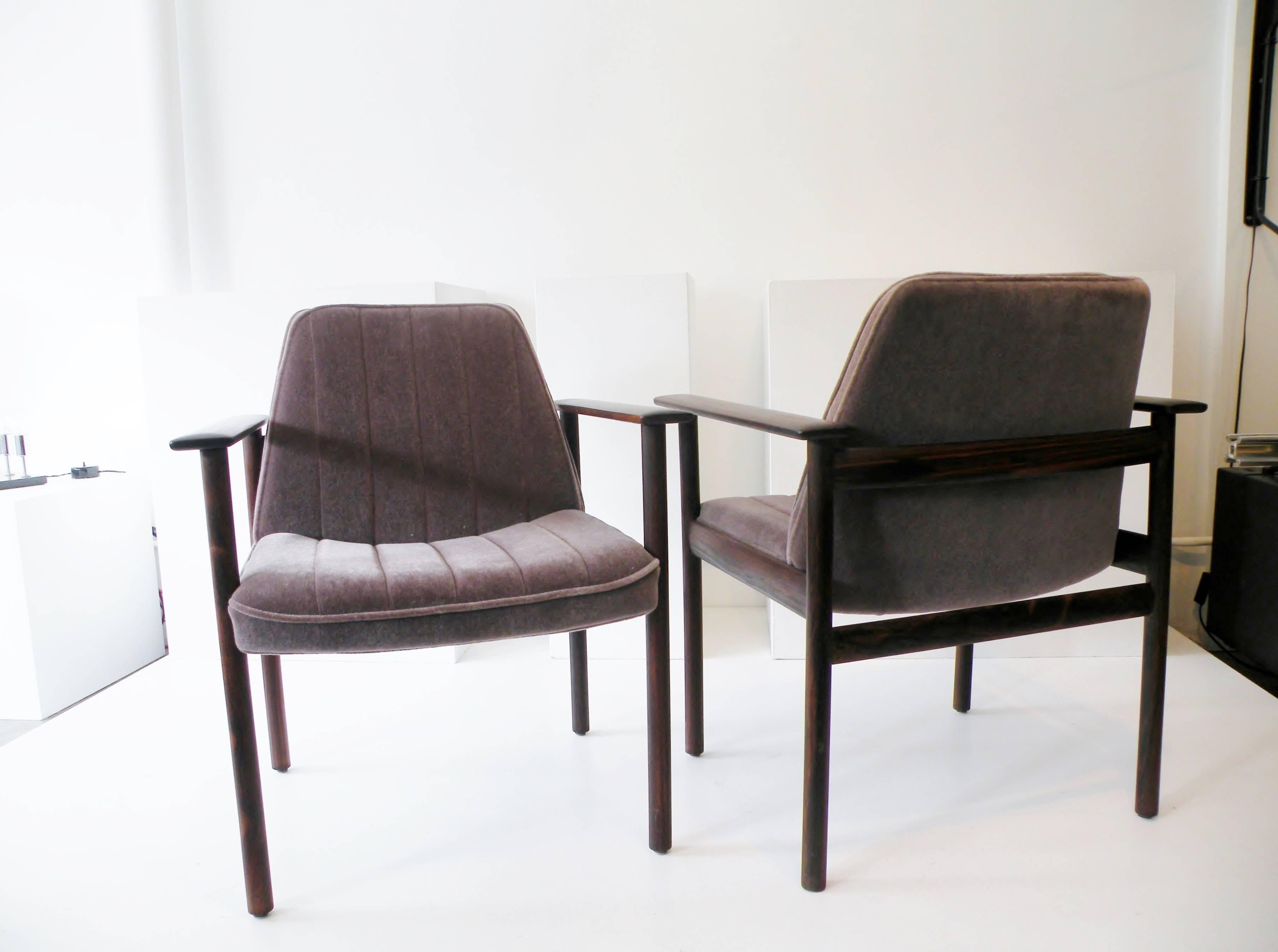 Architectural pair of solid rosewood executive lounge chairs. Made in Norway with design attributed to Frederik Kayser. Fine construction details with sculptural forms and floating backrest and visible mortise and tenon joinery, reupholstered in