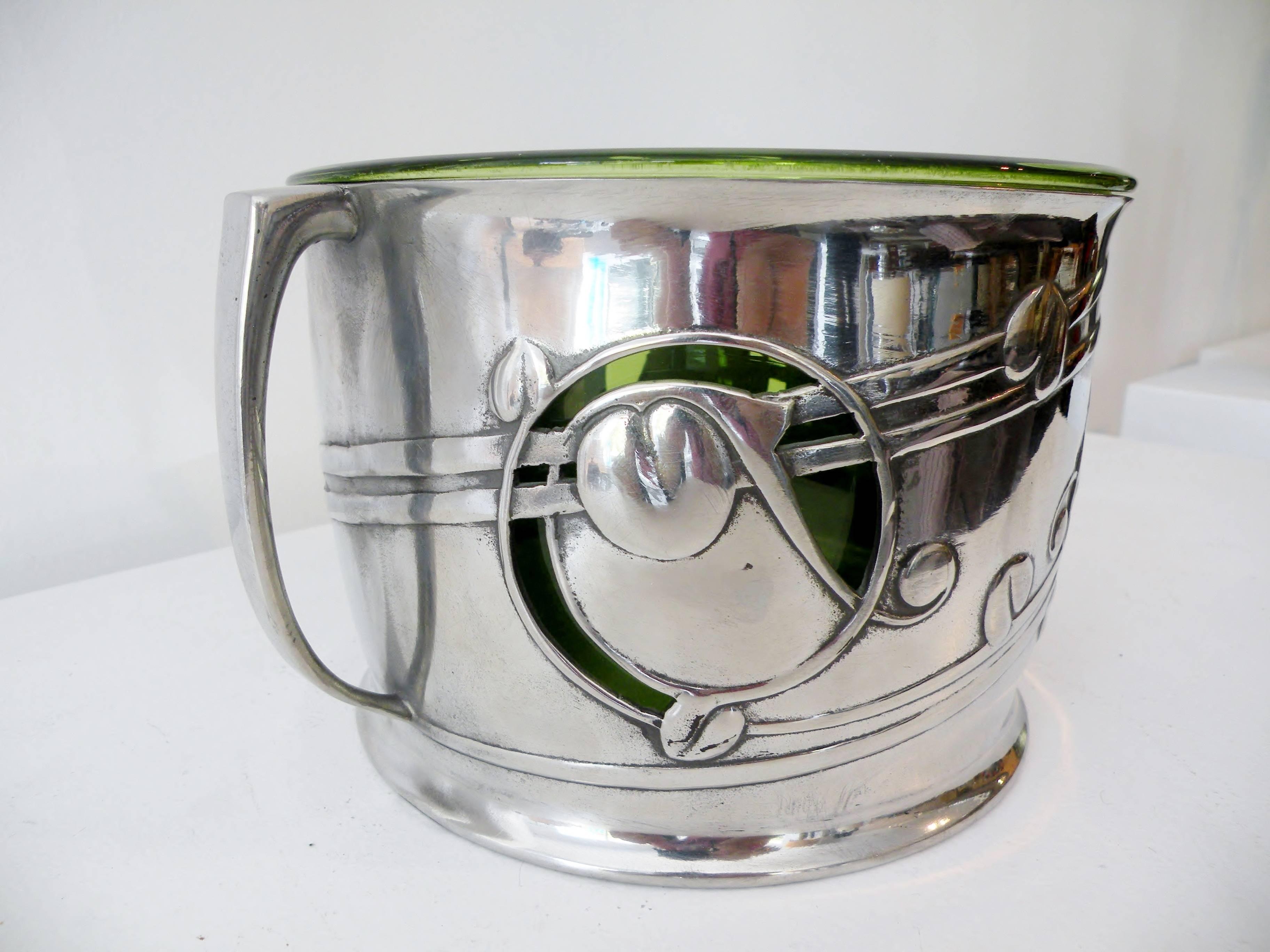 Early 20th century Archibald Knox tudric pattern wine chiller or bowl, model number 0964. Designed for London's Liberty & Co., crafted of pewter, and marked to base. Retains original James Cooper and Sons, Glasgow, green blown glass liner. Measures