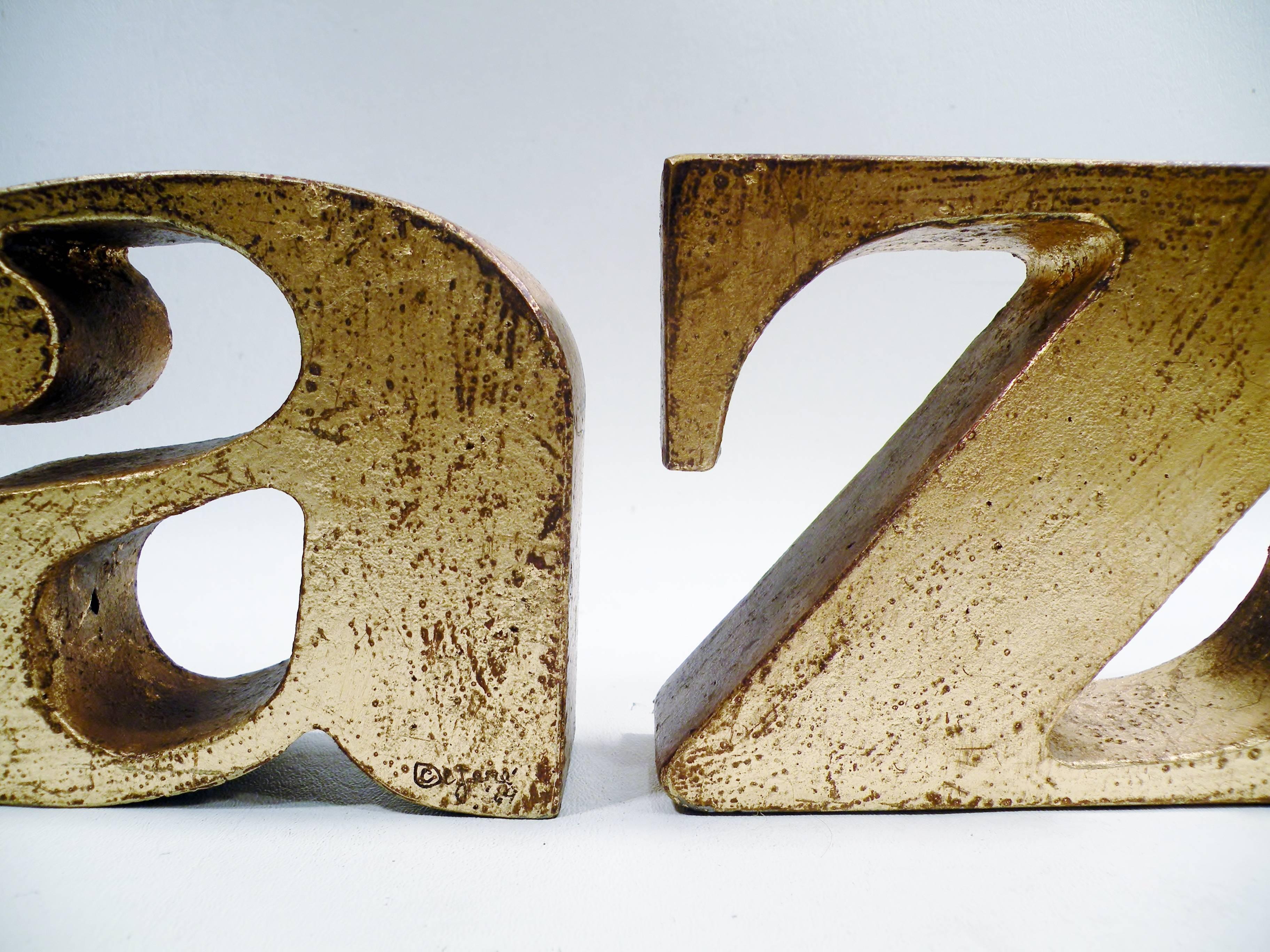Pair of heavy gilded cast iron A to Z bookends from the renowned studios of Curtis Jere. Each signed C. Jere and dated ’69 measuring 4.5