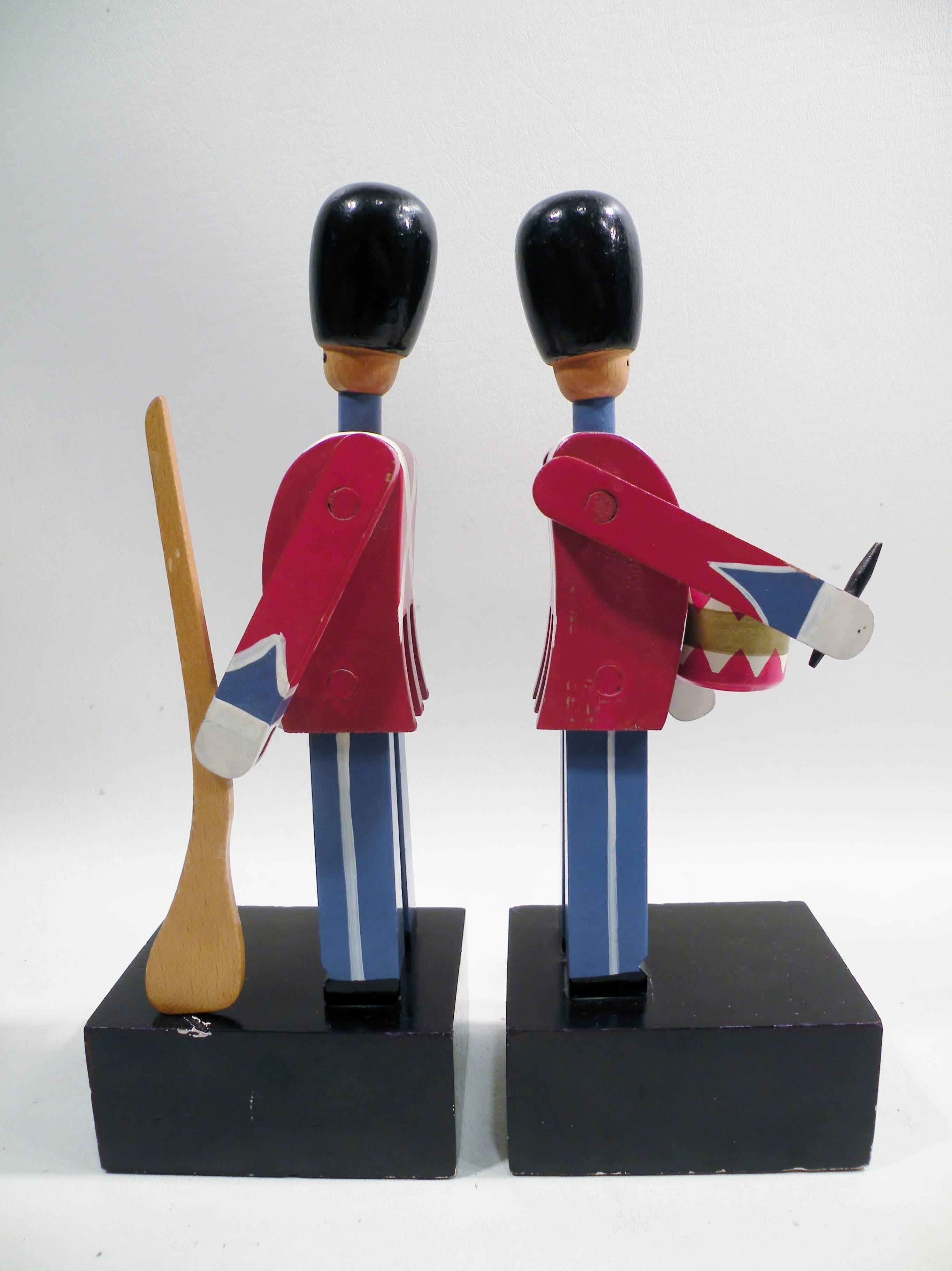 Rarely seen pair of 1960s Kay Bojesen wooden Royal Guardsman bookends. Each 10.5” tall on weighted base.  A drummer and rifleman, both marked Kay Bojesen, Copenhagen, Denmark to inside of leg. 

In as found condition, very good overall with bits