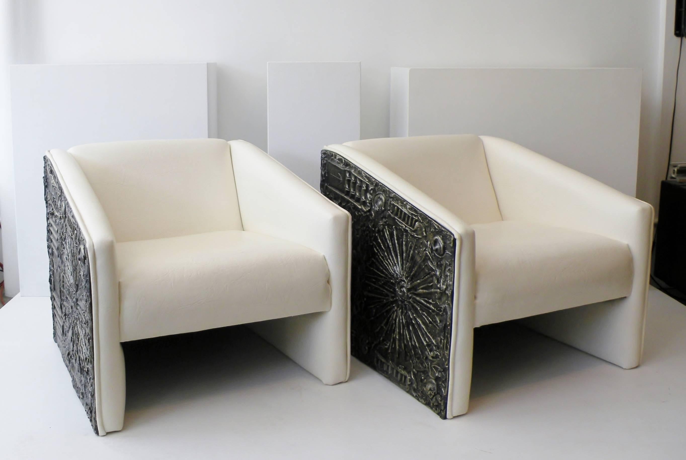Pair of Adrian Pearsall for his Craft Associates Furniture company tuxedo arm lounge chairs. An Brutalist abstract cast panel to sides and back with original man made off-white textured leather upholstery.