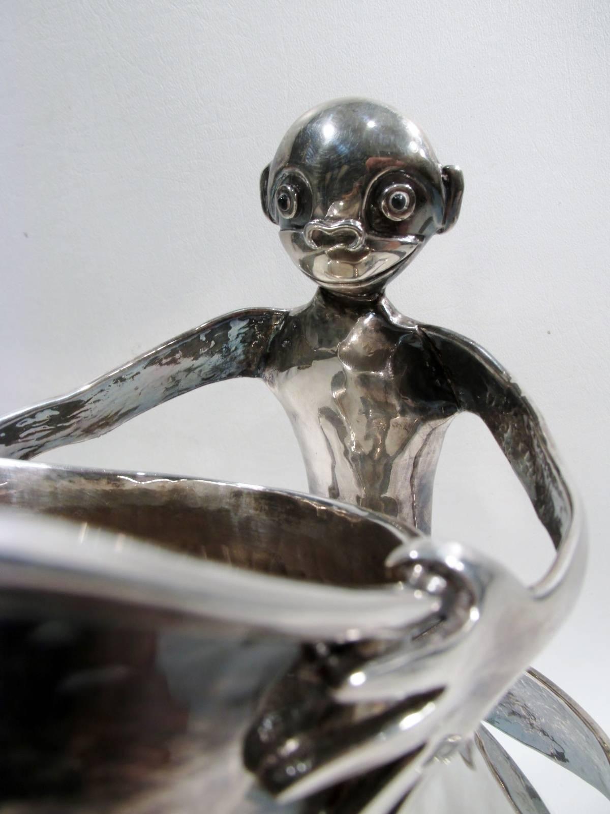 Fine figural drink pitcher from the renowned Taxco Mexico workshop of Emilia Castillo. Heavy silver plate on copper with whimsical monkey form handle and hand-hammered surface finish.

Emilia descends from a fine family tree of renowned Taxco