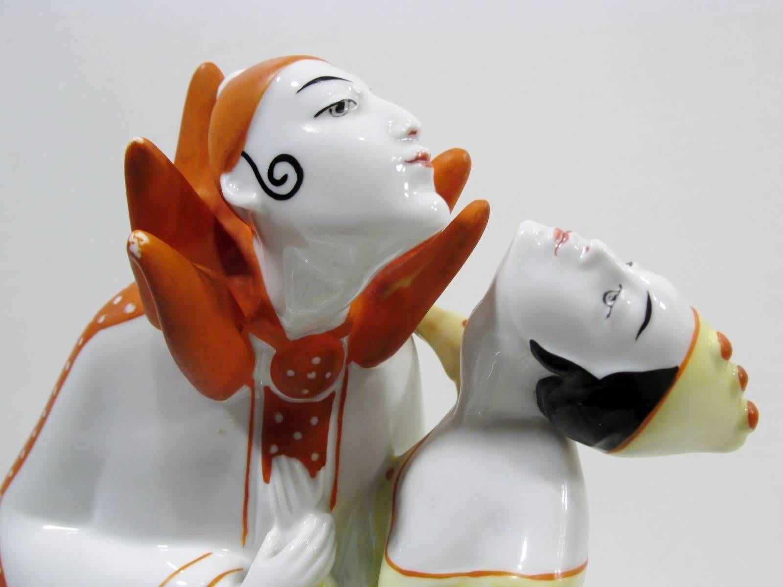 Fine German Art Deco porcelain figural group depicting the romantic couple Pierrot & Columbine. Beautifully modeled with classic stylized Art Deco figures and hand cold painted details. This piece dates to the 1920s after the renowned Fraureuth
