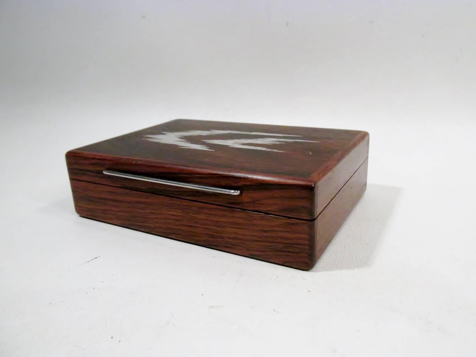 1960s Danish jeweler Axel Salomonsen designed dresser box. Box appears to be of rosewood however truly ancient Danish bog wood which has taken on a rosewood color after centuries submerged in a bog. Abstract sterling silver inlay decoration to lid