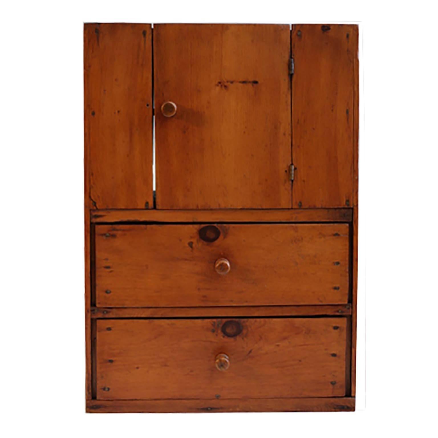 Primitive southern pine cabinet with square nailheads and hand-turned knobs.