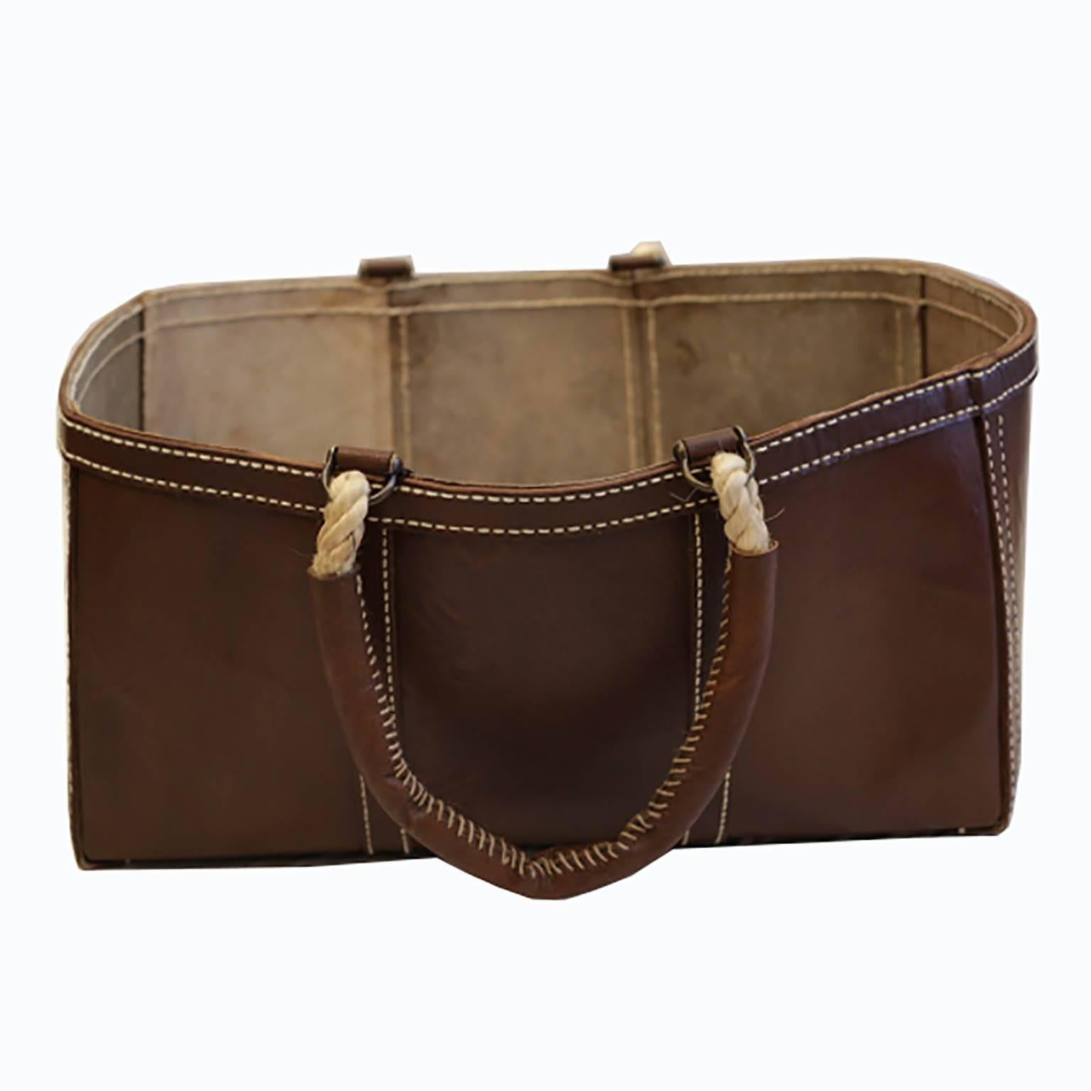 Sturdy buffalo leather in a brown finish with white hand stitching, natural rope handles, and bronze fittings.
Dimensions: 24.5'' x 16'' x 12''
Color: Brown.
 
